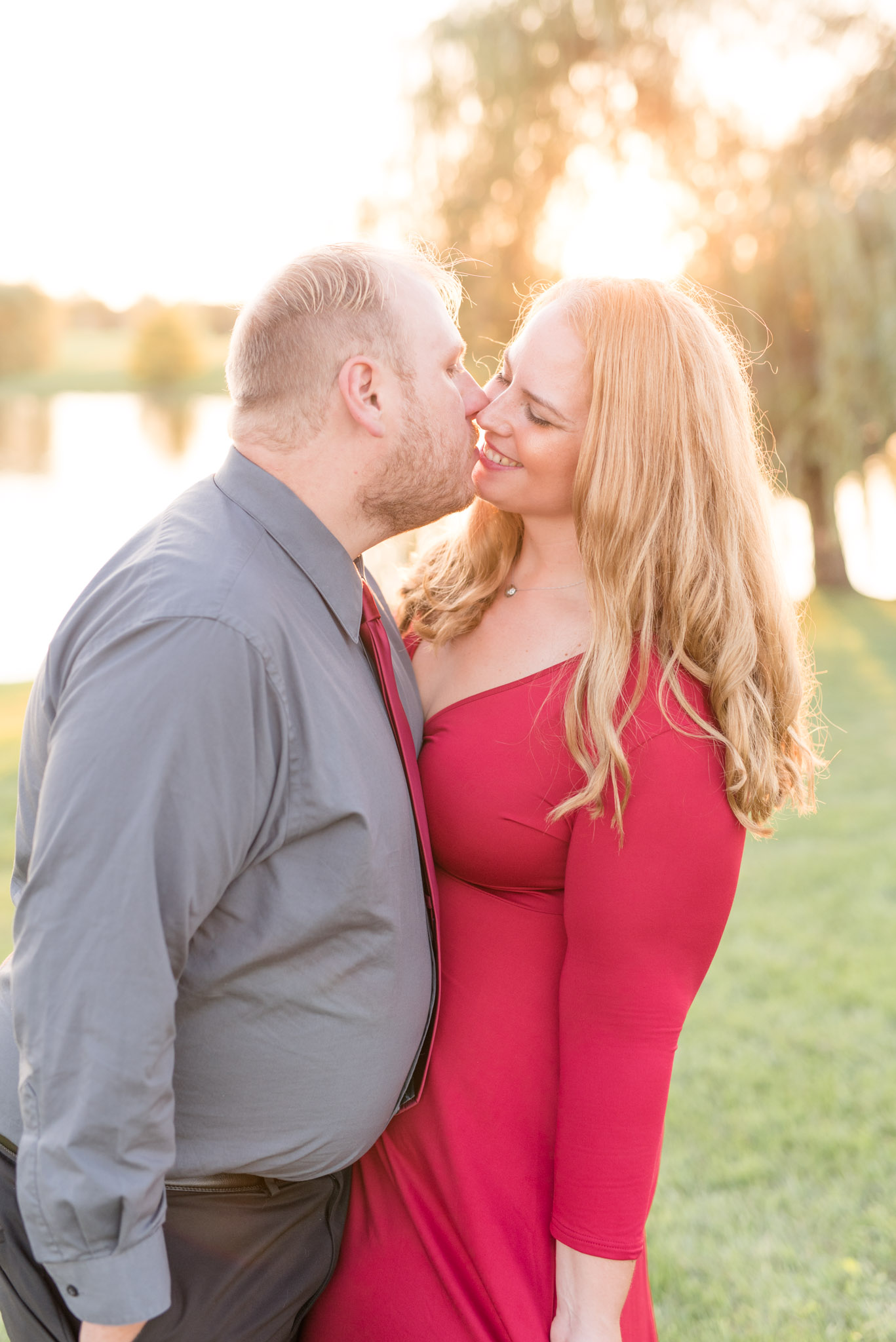 Engaged couple kiss at sunset.