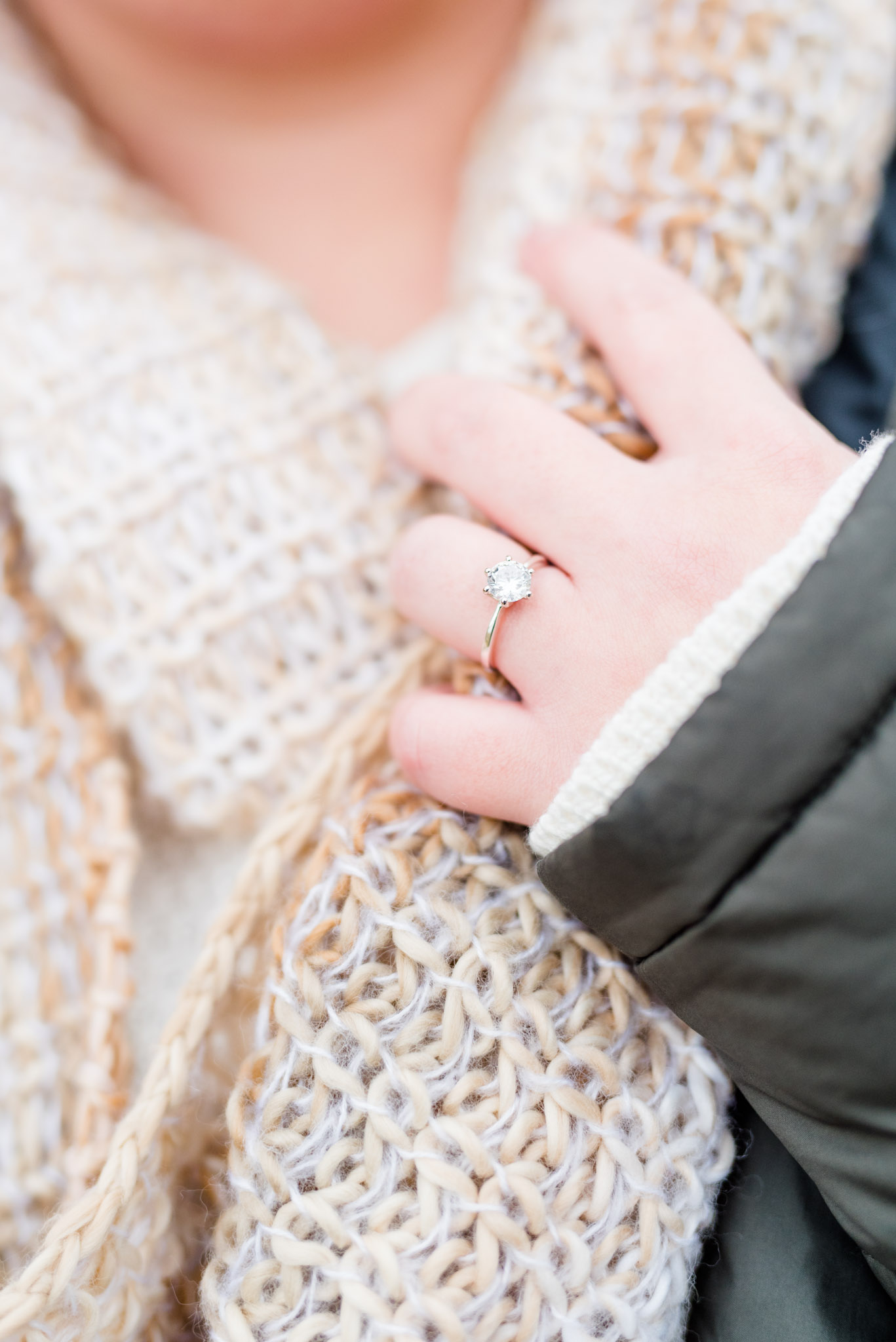 Bride wears engagement ring and holds scarf during session.