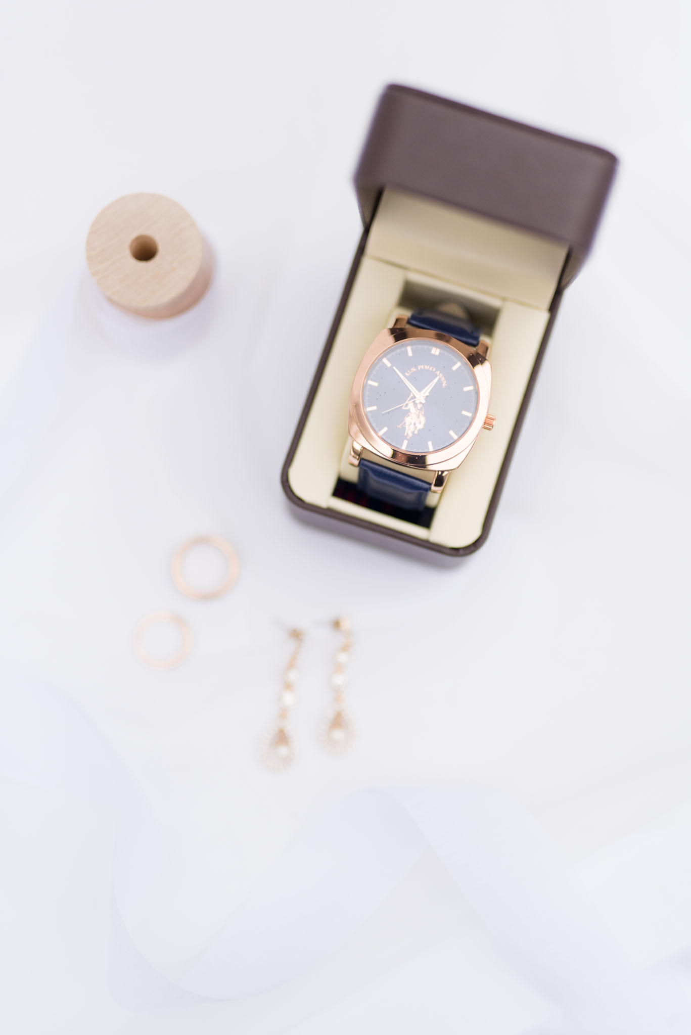 Wedding Details and a Ralph Lauren Polo Watch sit on white fabric.