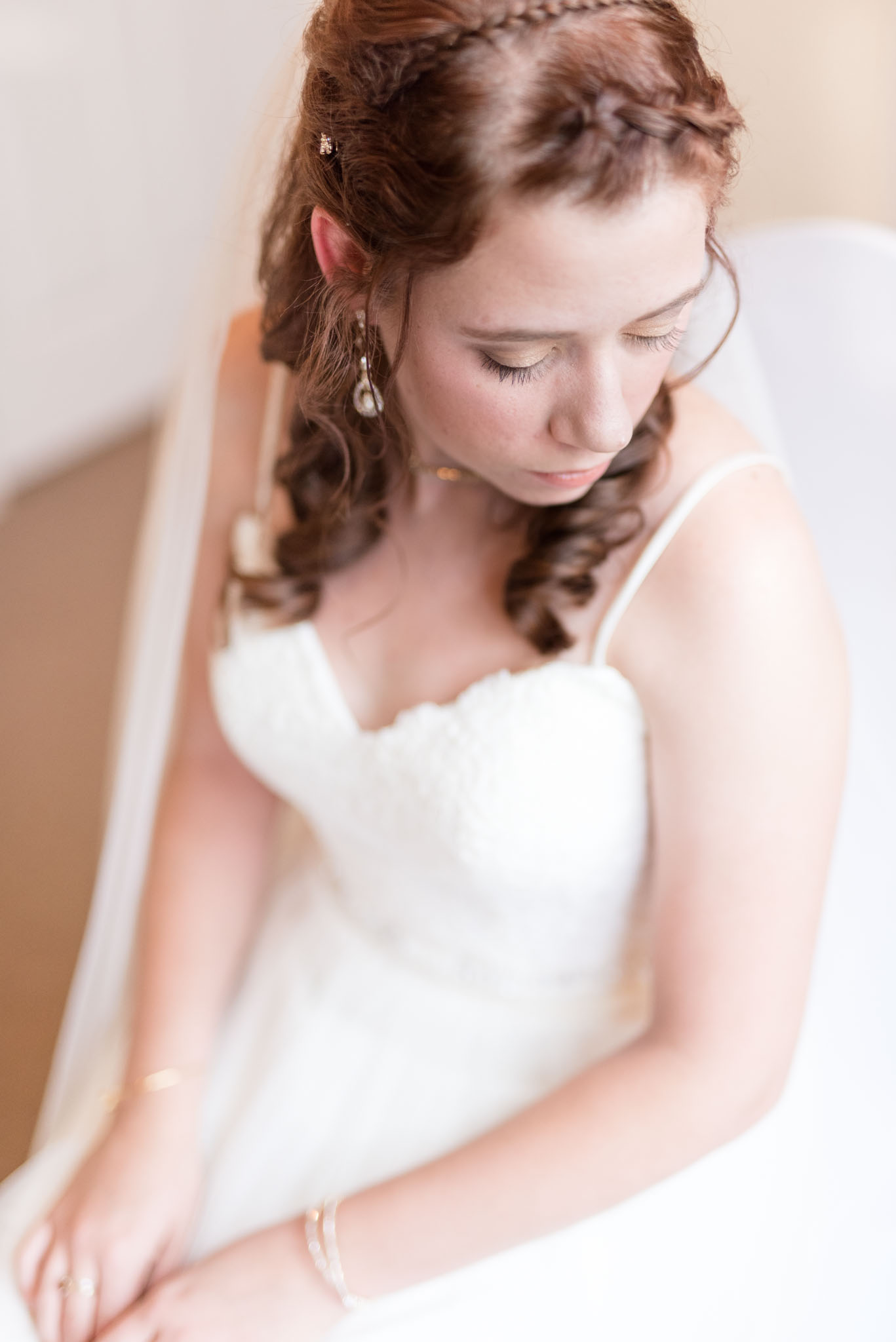 Bride looks over shoulder while getting ready.
