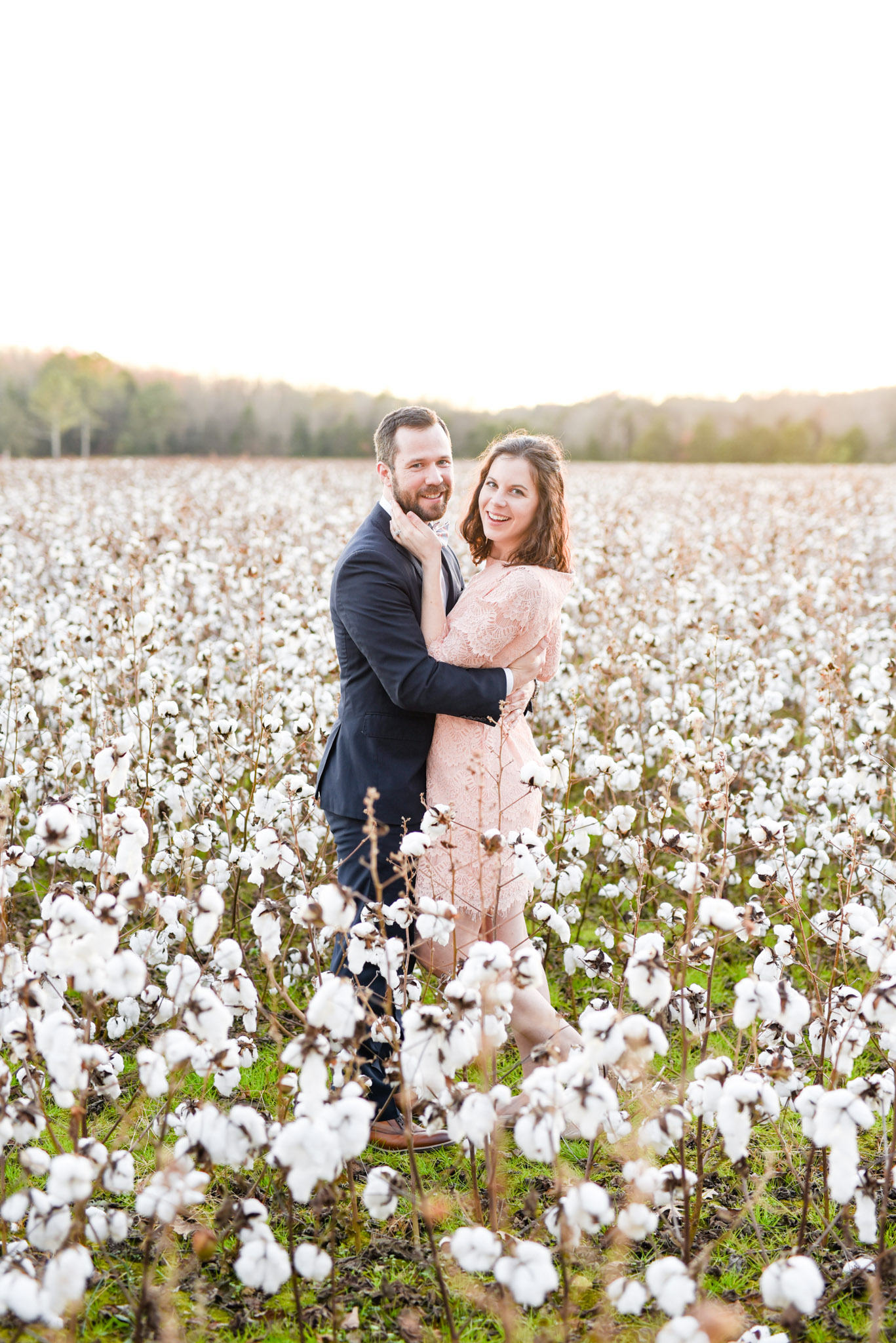 Couple laughs in cotton field.