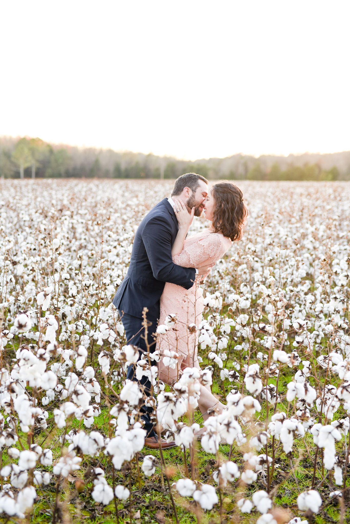 Couple almost kisses in cotton field.