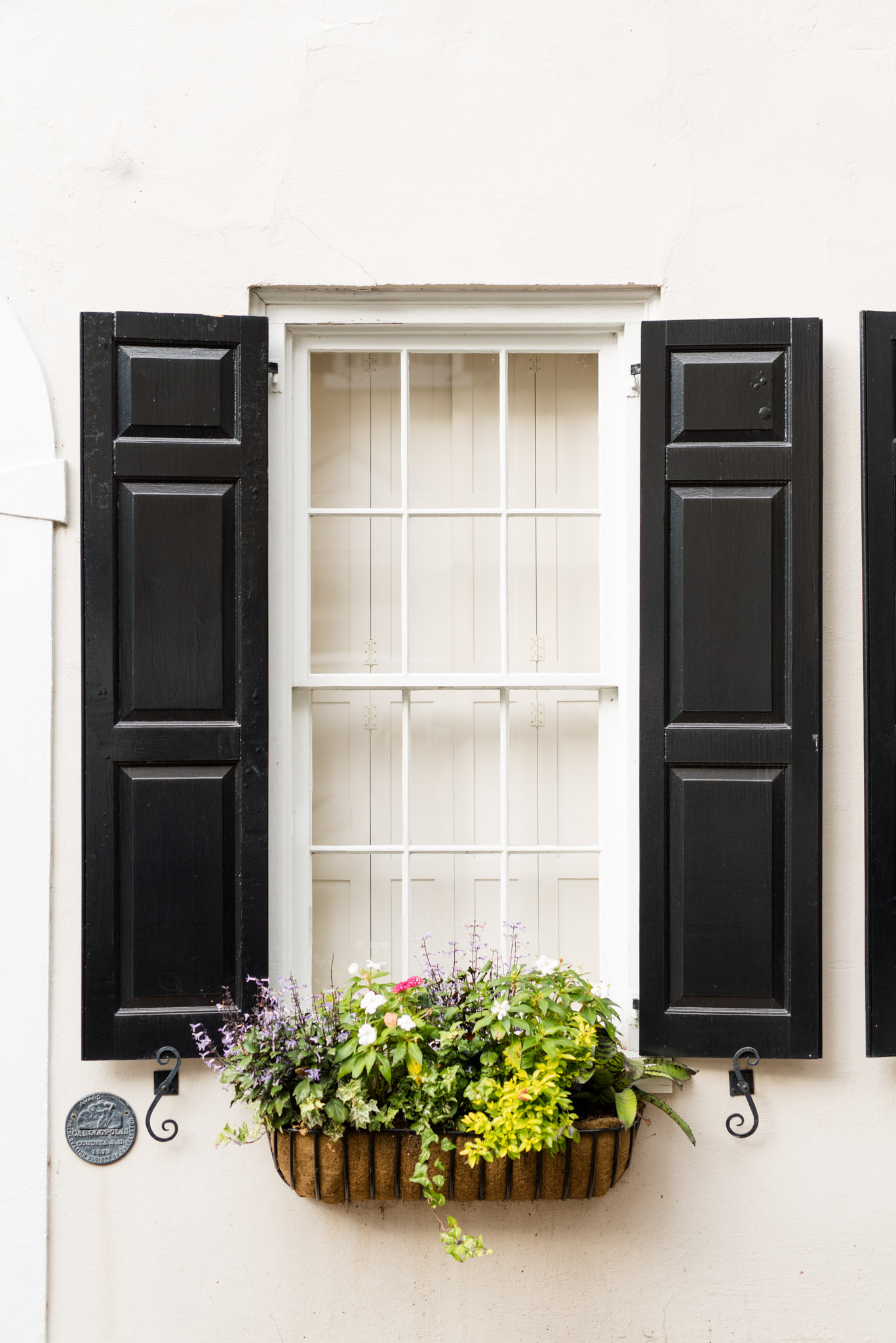 Black shutters on white window and wall