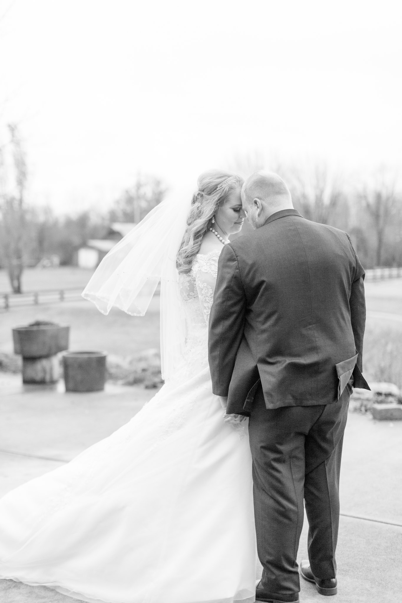 Bride and Groom touch heads together on windy wedding day.