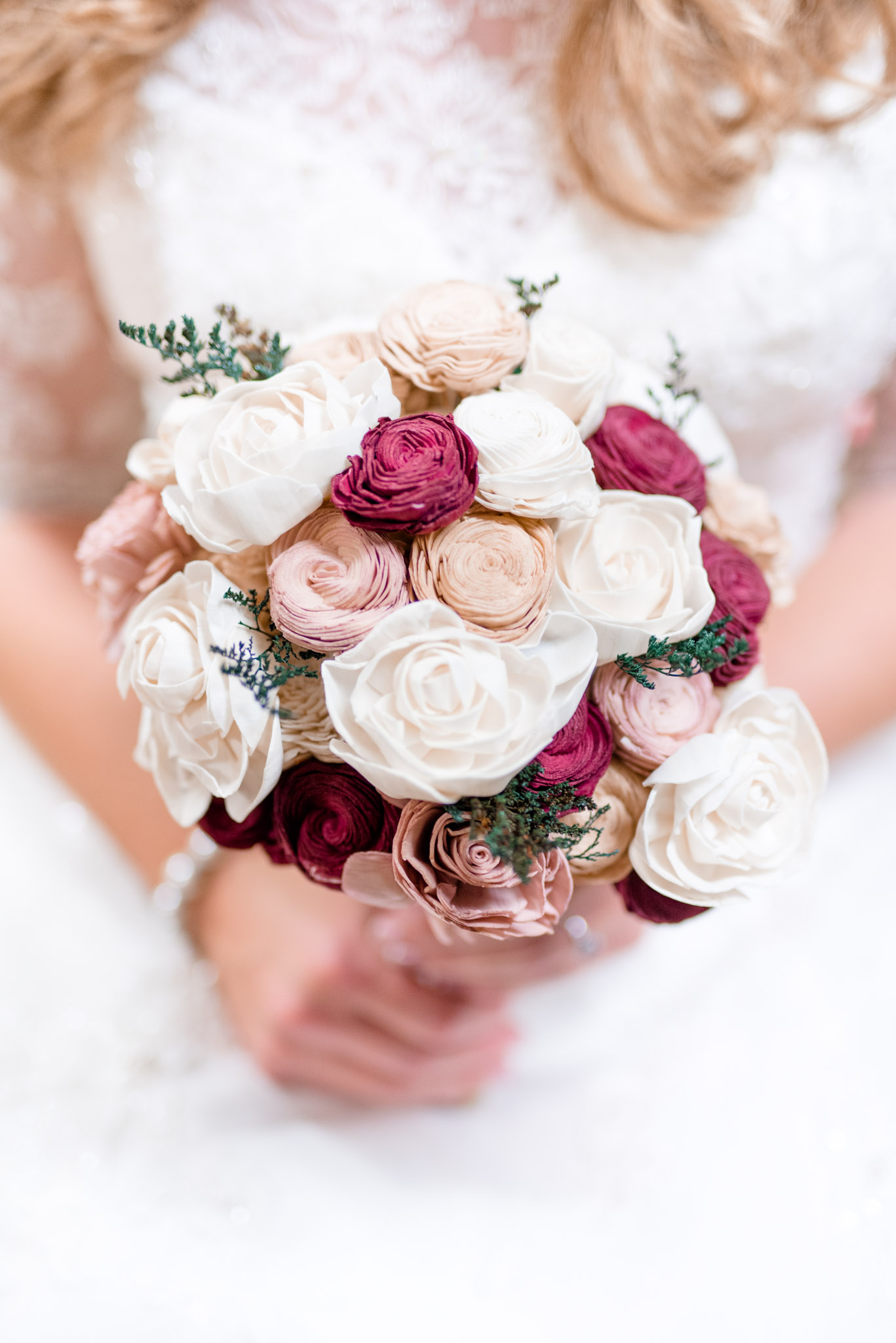 Bride holds her boquet of wooden flowers.