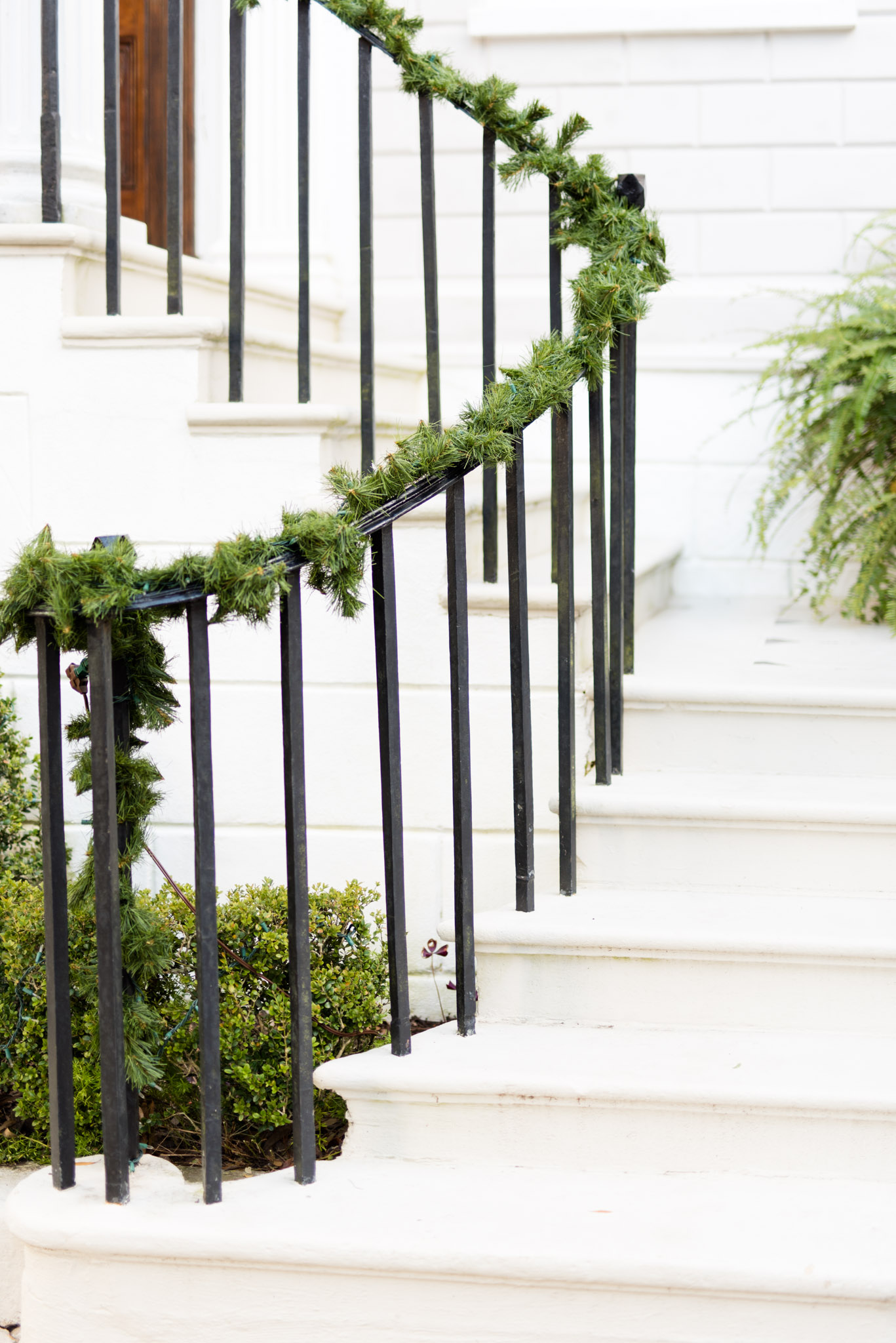White marble staircase with iron railing and garland
