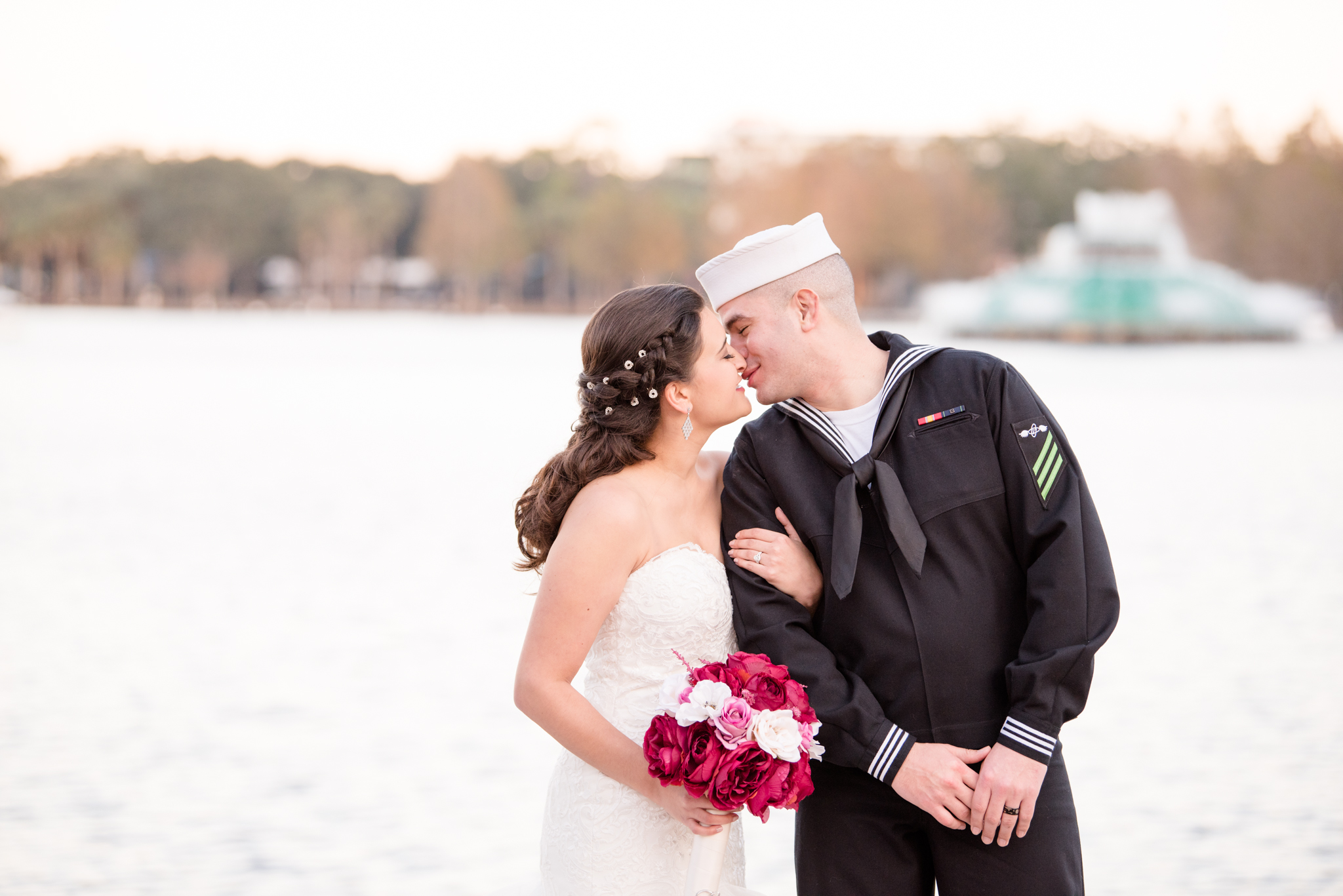 Bride and groom kiss at sunset overlooking Lake Eola.