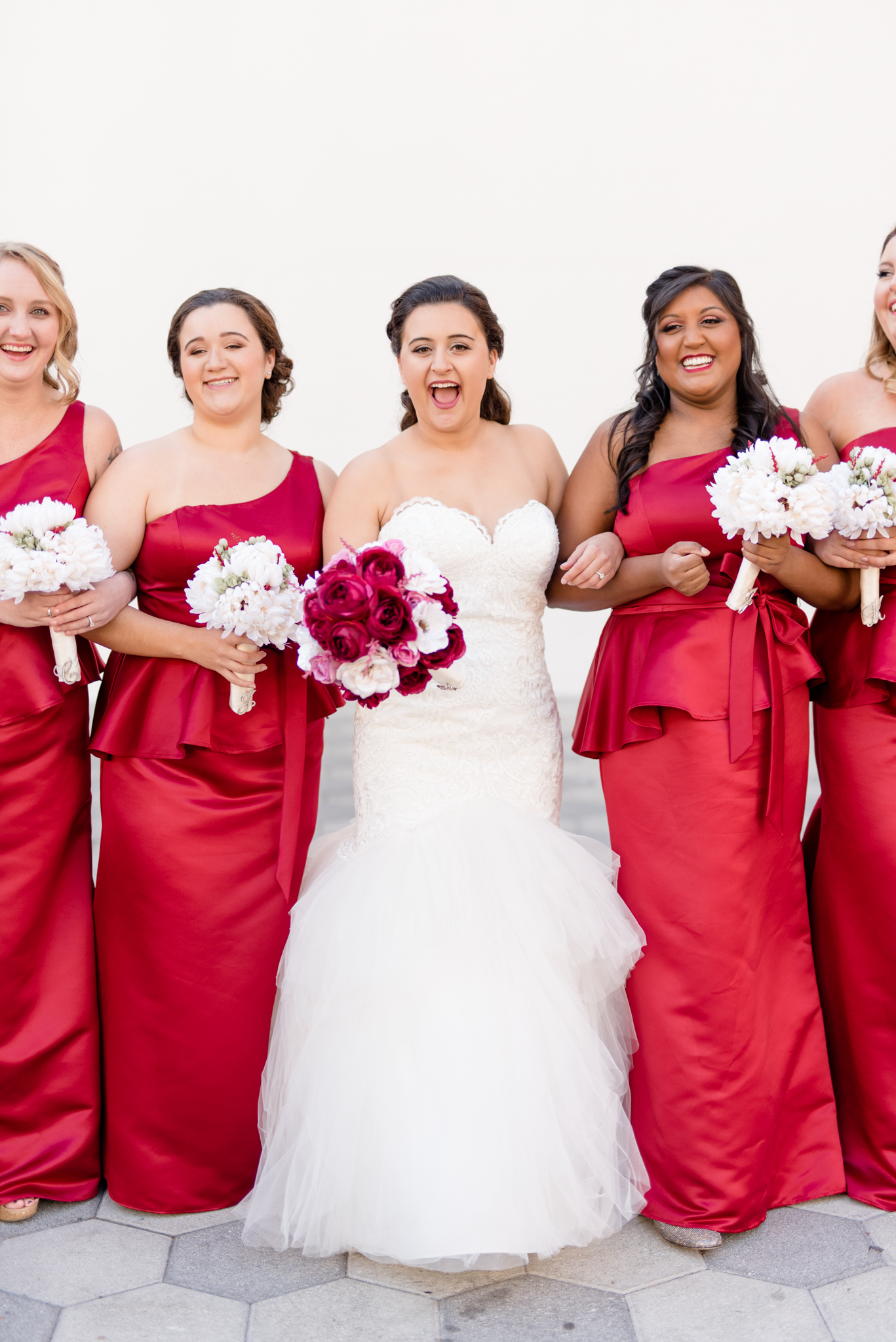 Bride smiles while walking with bridesmaids.