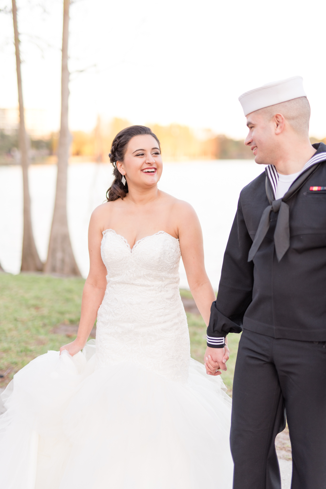 Bride laughs as couple walks next to Lake Eola.