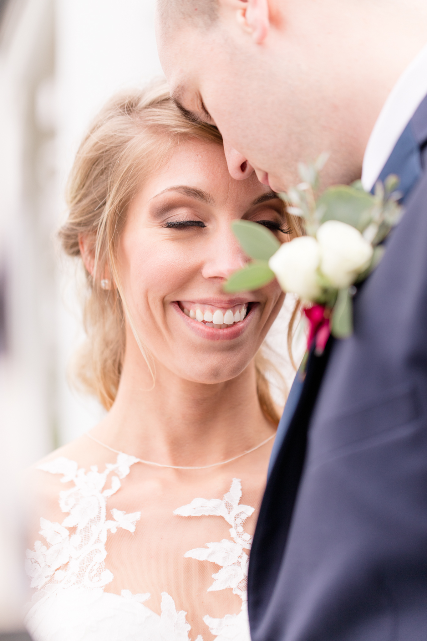 Bride and groom smile as the touch foreheads.