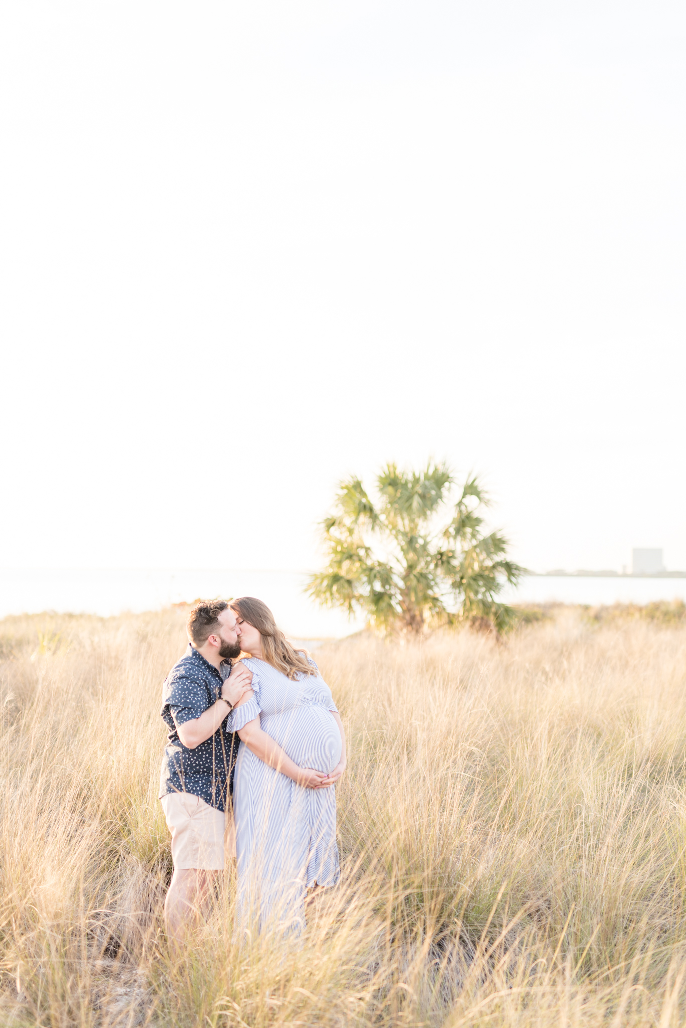 Couple kisses during Cypress Point Park Maternity Session