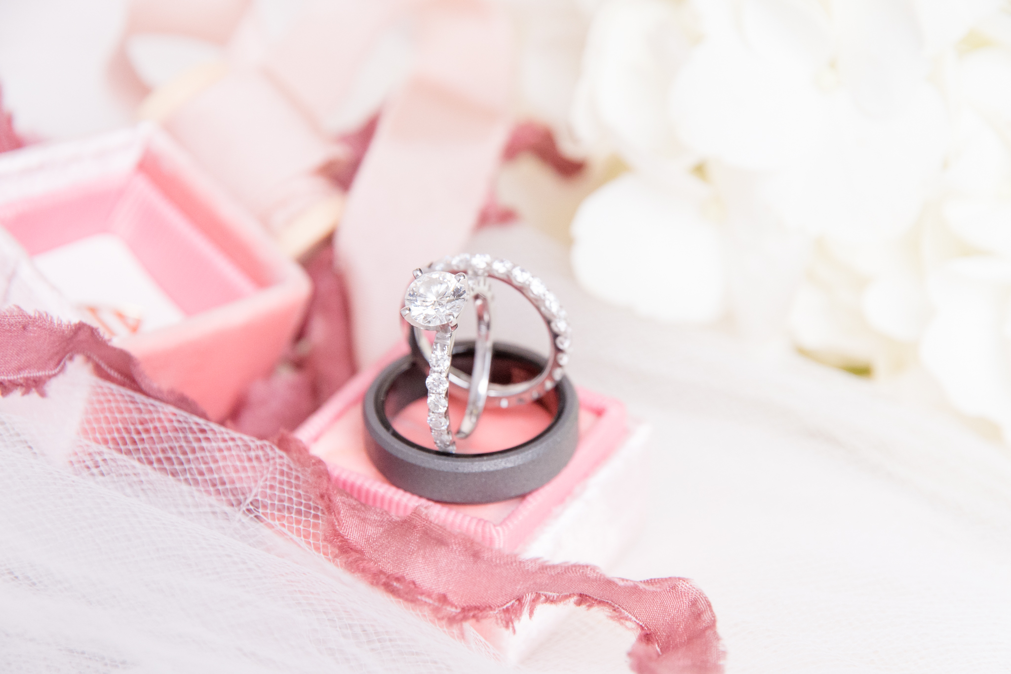 Enagement ring sits with ribbon and flowers.