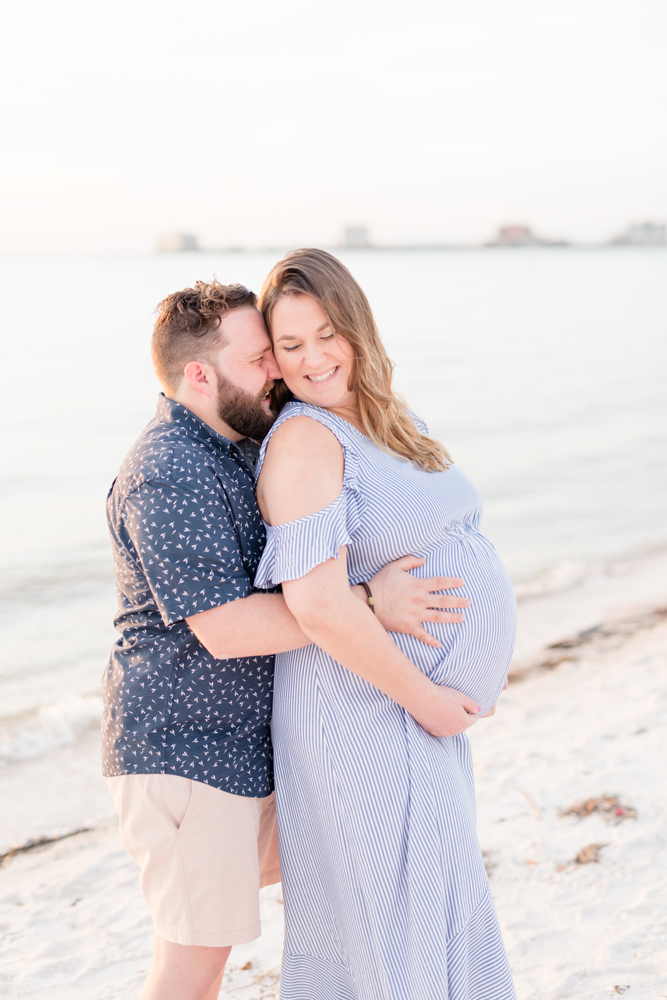 Expecting couple smiles on Tampa beach maternity session