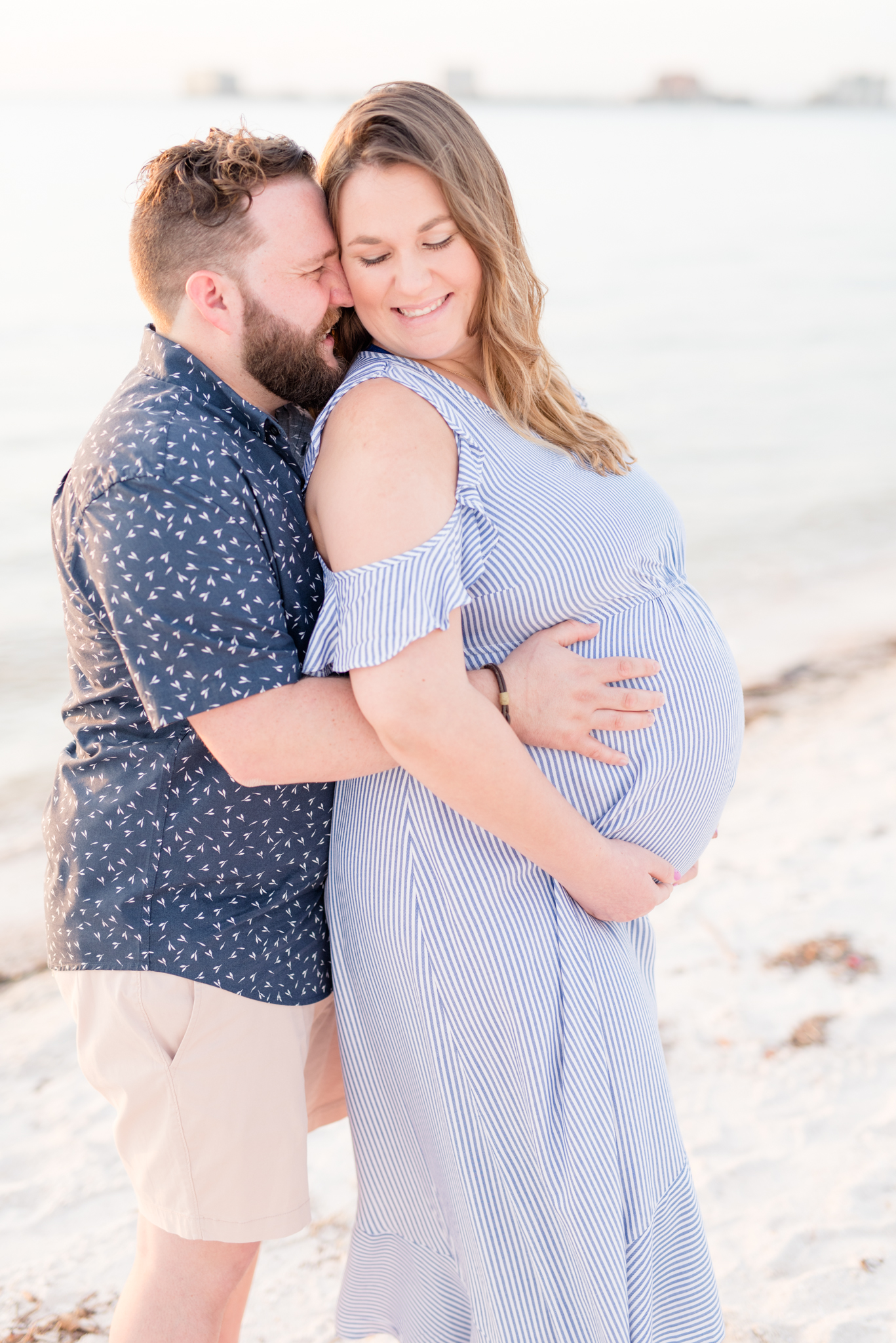 Couple laughs during Tampa Beach maternity pictures