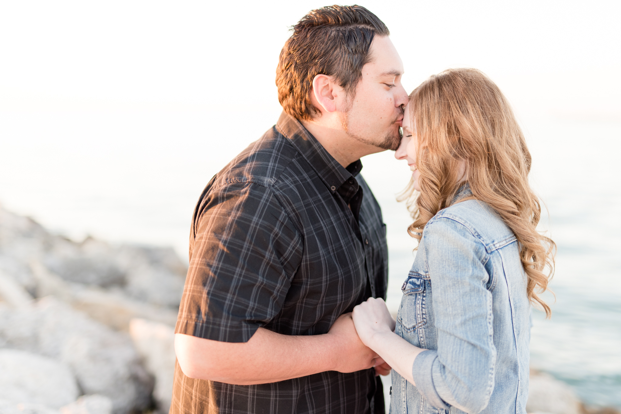 Man kisses fiance on forehead.