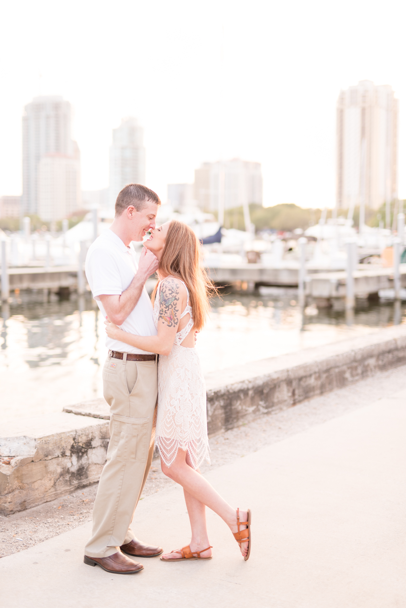 Engaged couple almost kiss in front of St. Petersburg harbor.