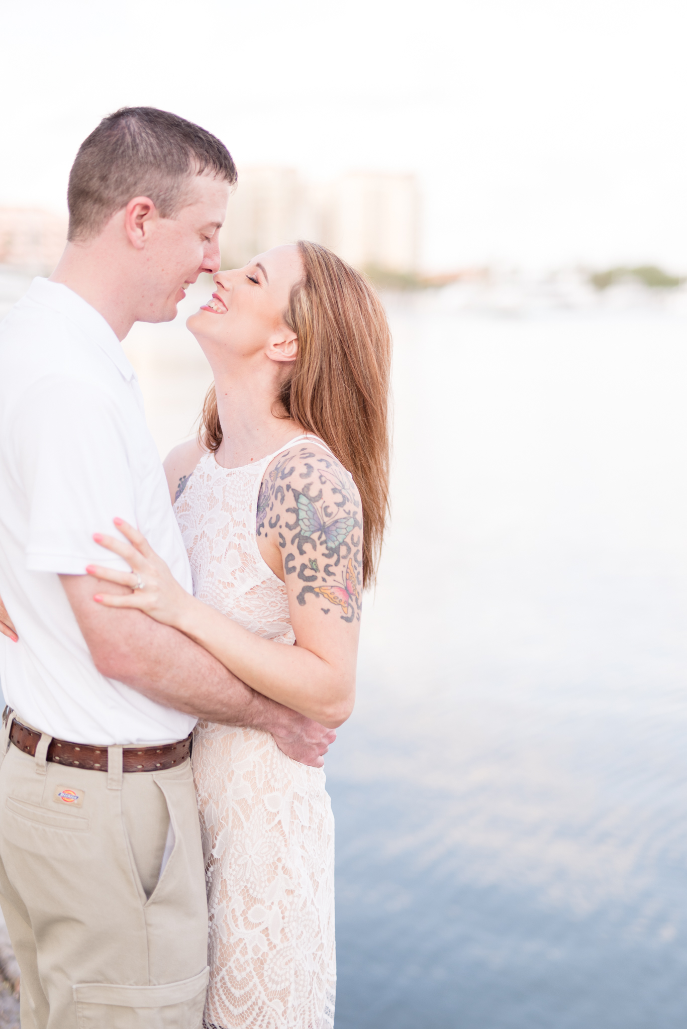 Man and woman smile next to the ocean at St. Petersburg, FL.