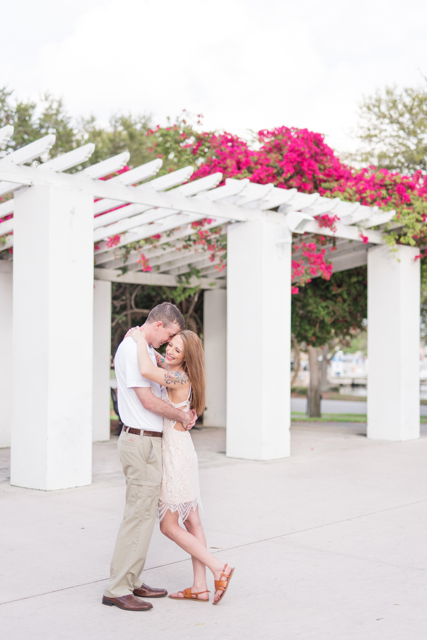 Man and woman smile under flowering arbor in St. Petersburg