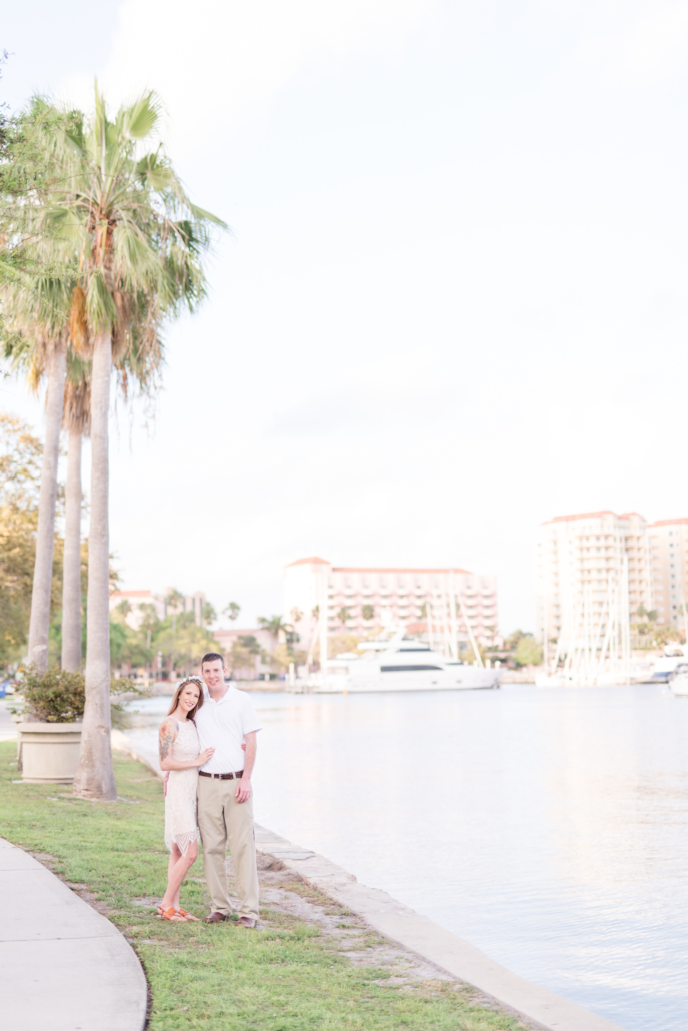 Engaged couple stand next to water at North Straub Park.