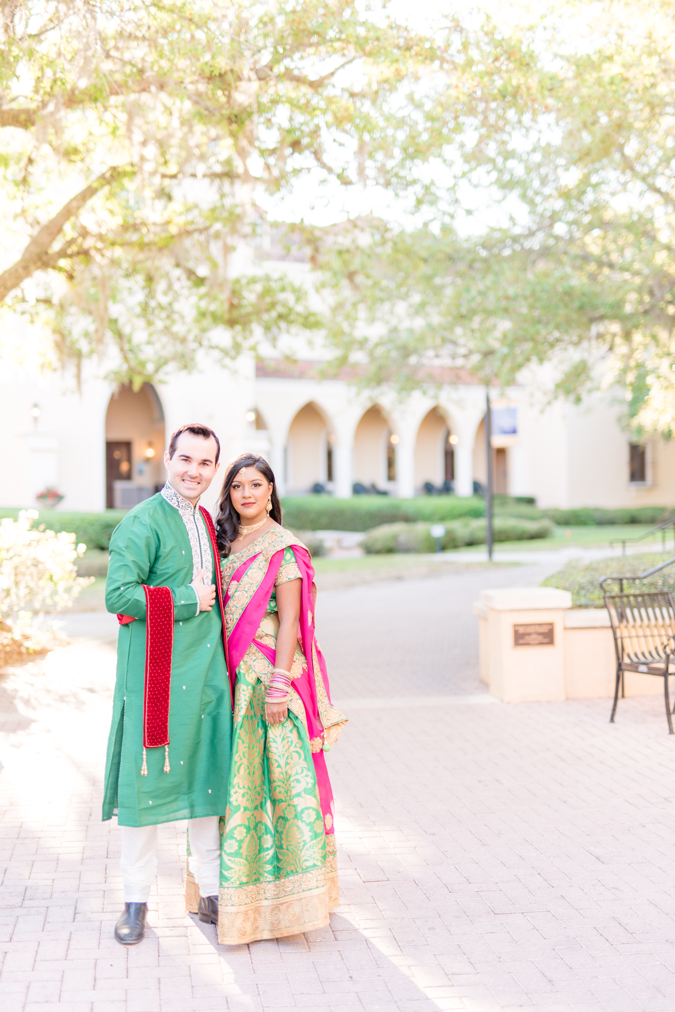 Man and woman smile at camera in Indian outfits.