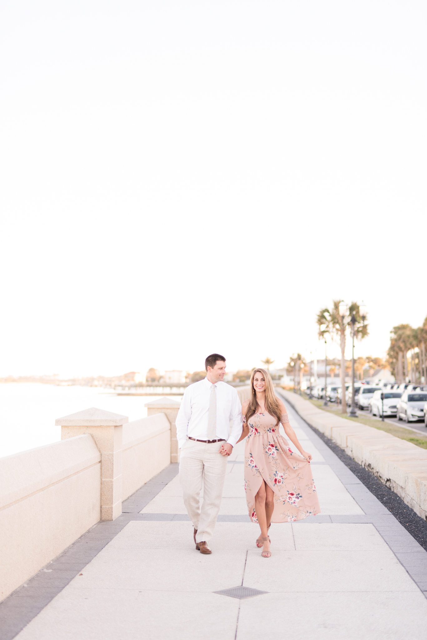 Man and woman walk along St. Augustine coast.
