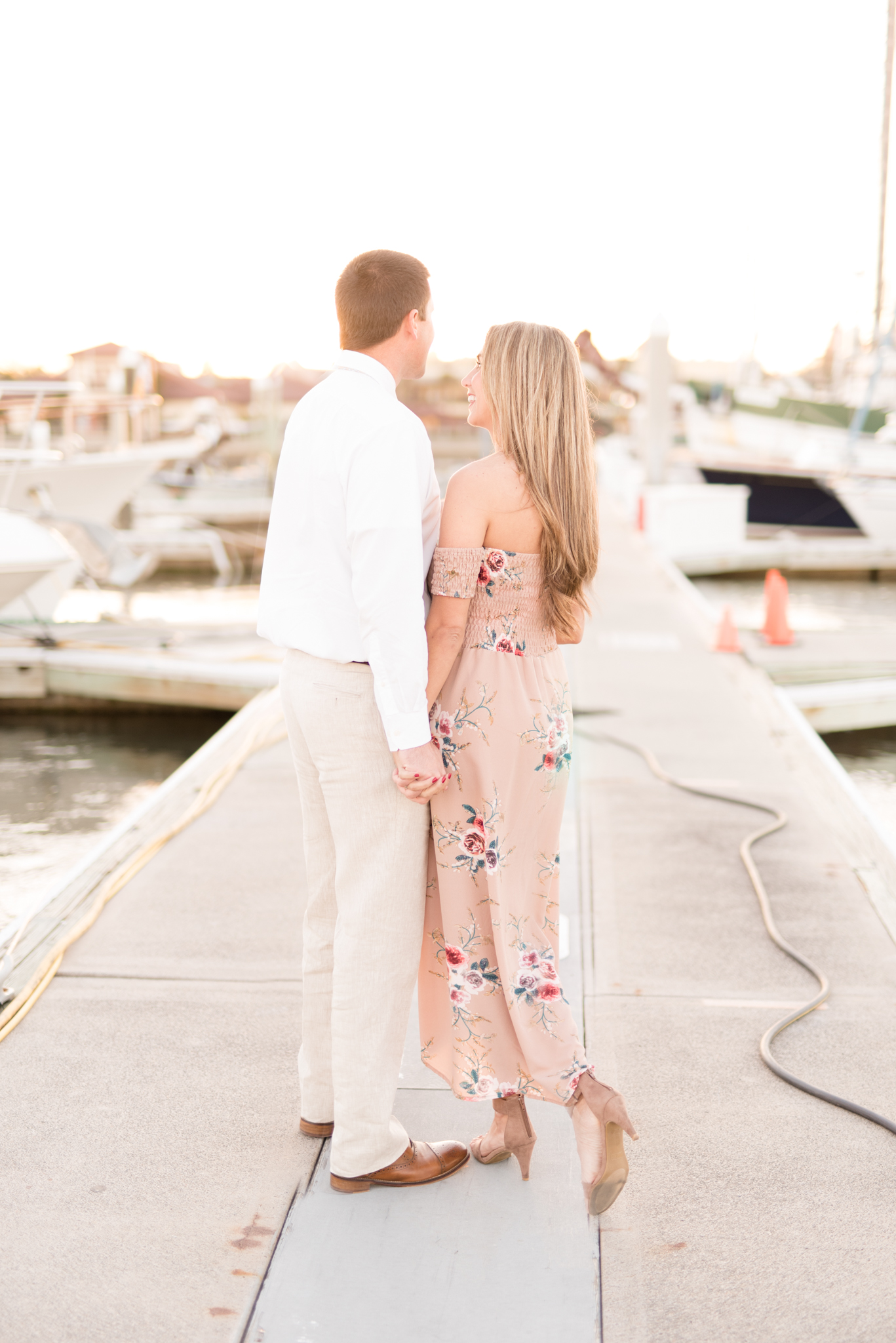 Married couple stands on a dock.