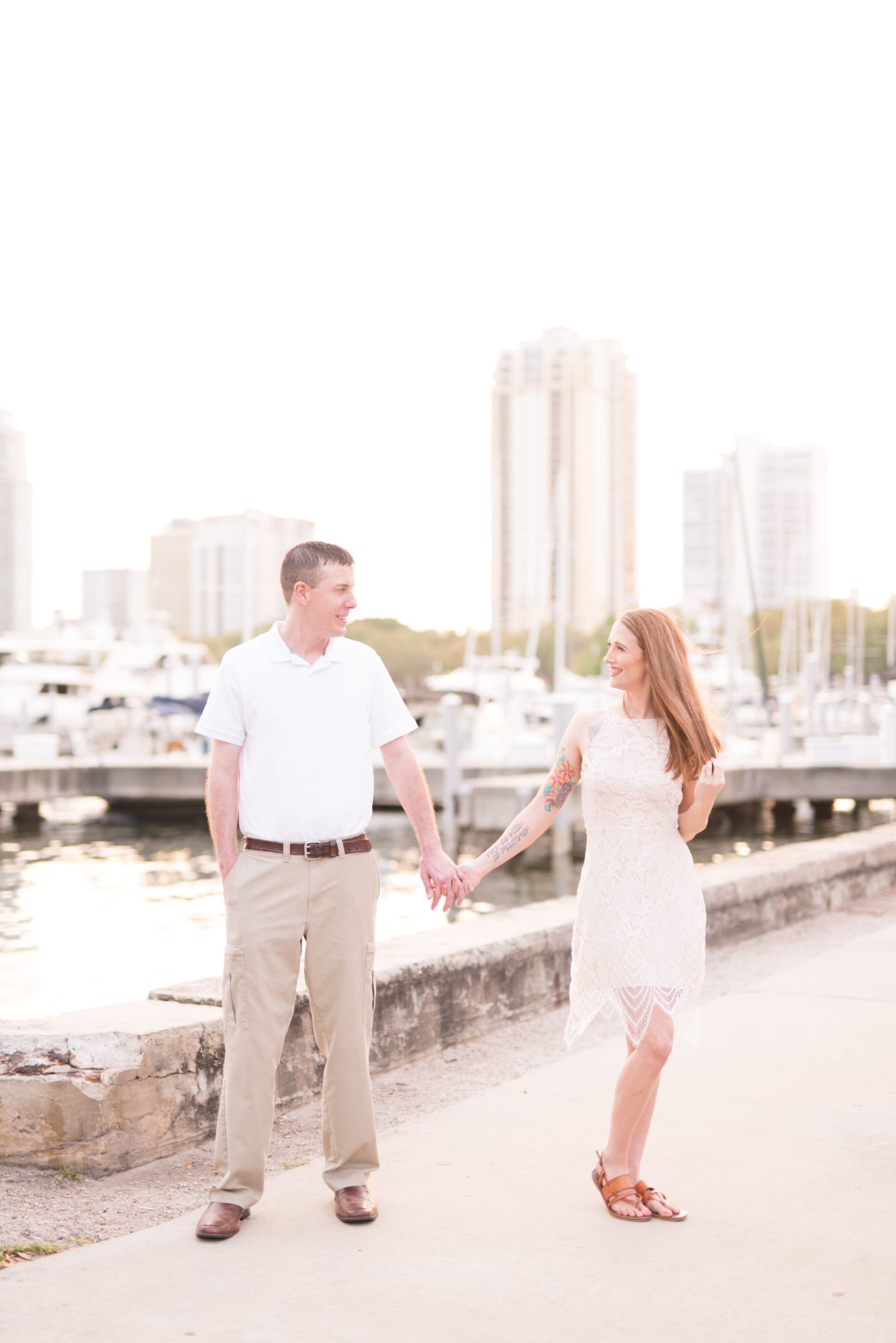 Man and woman stand next to St. Petersburg Marina at sunset.