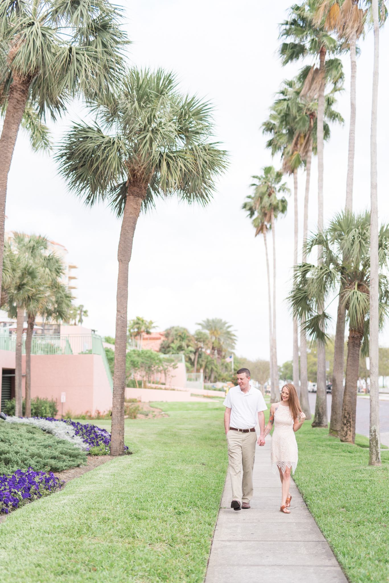 Couple smiles and walks next to The Vinoy Hotel.