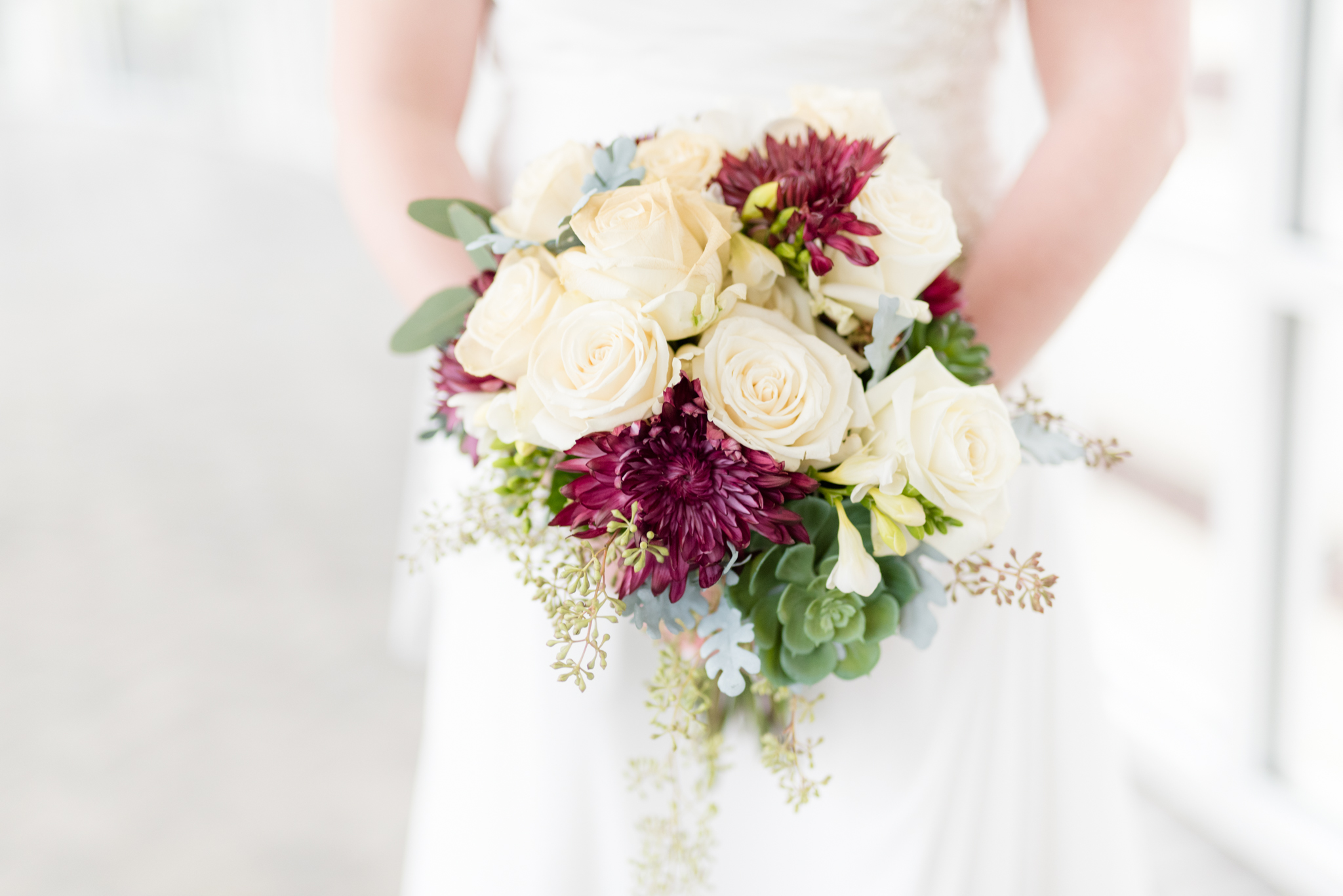 Bridal bouquet with purple and cream flowers.