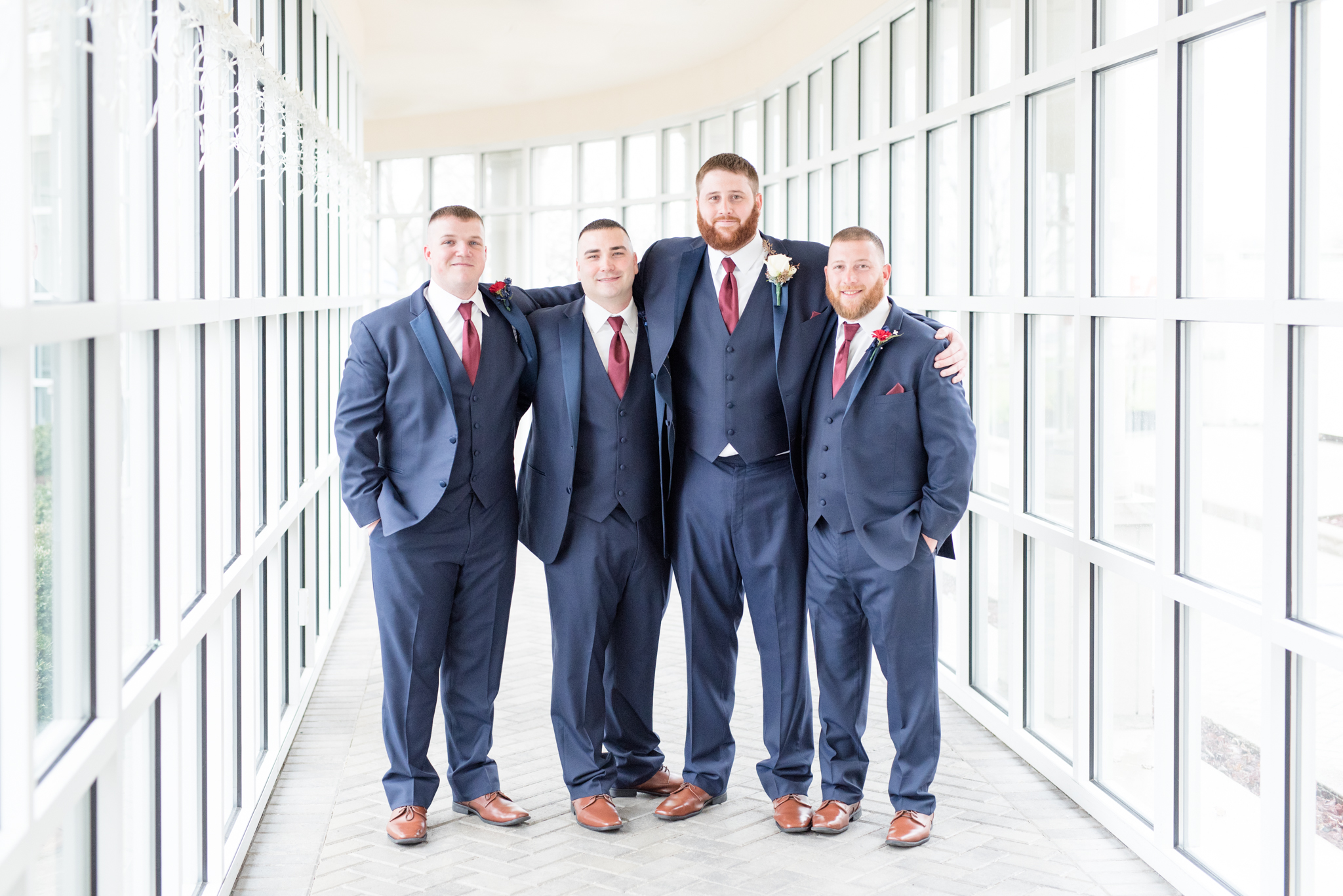 Groom and groomsmen put arms around each other.
