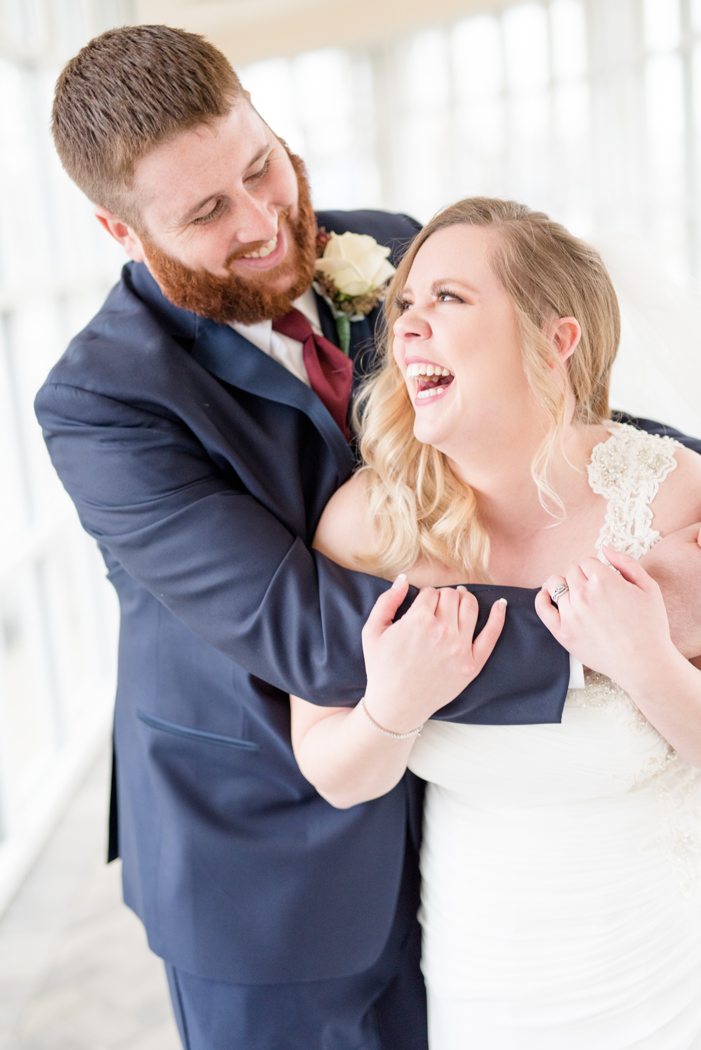 Groom holds his laughing bride.
