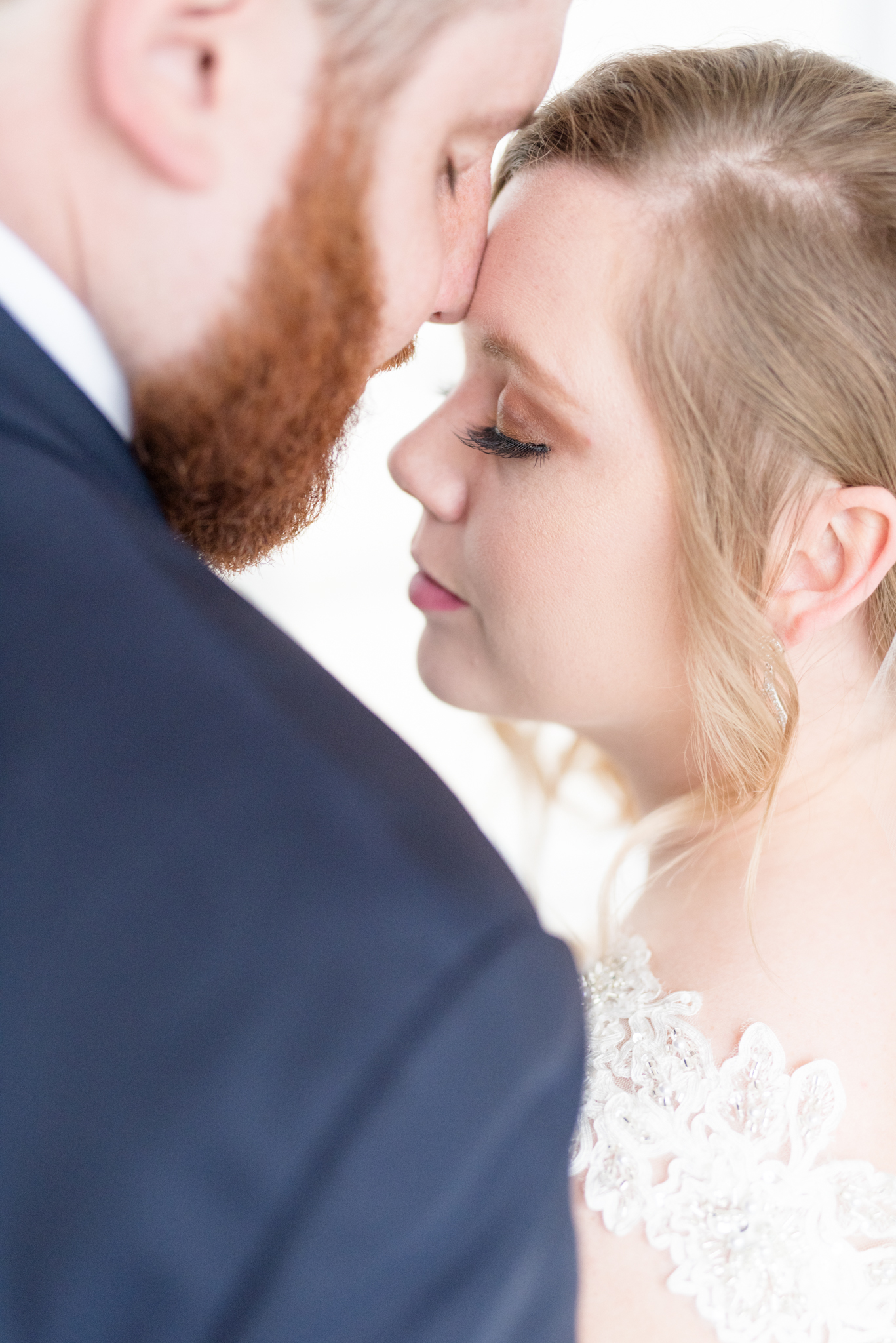 Bride and groom snuggle together.