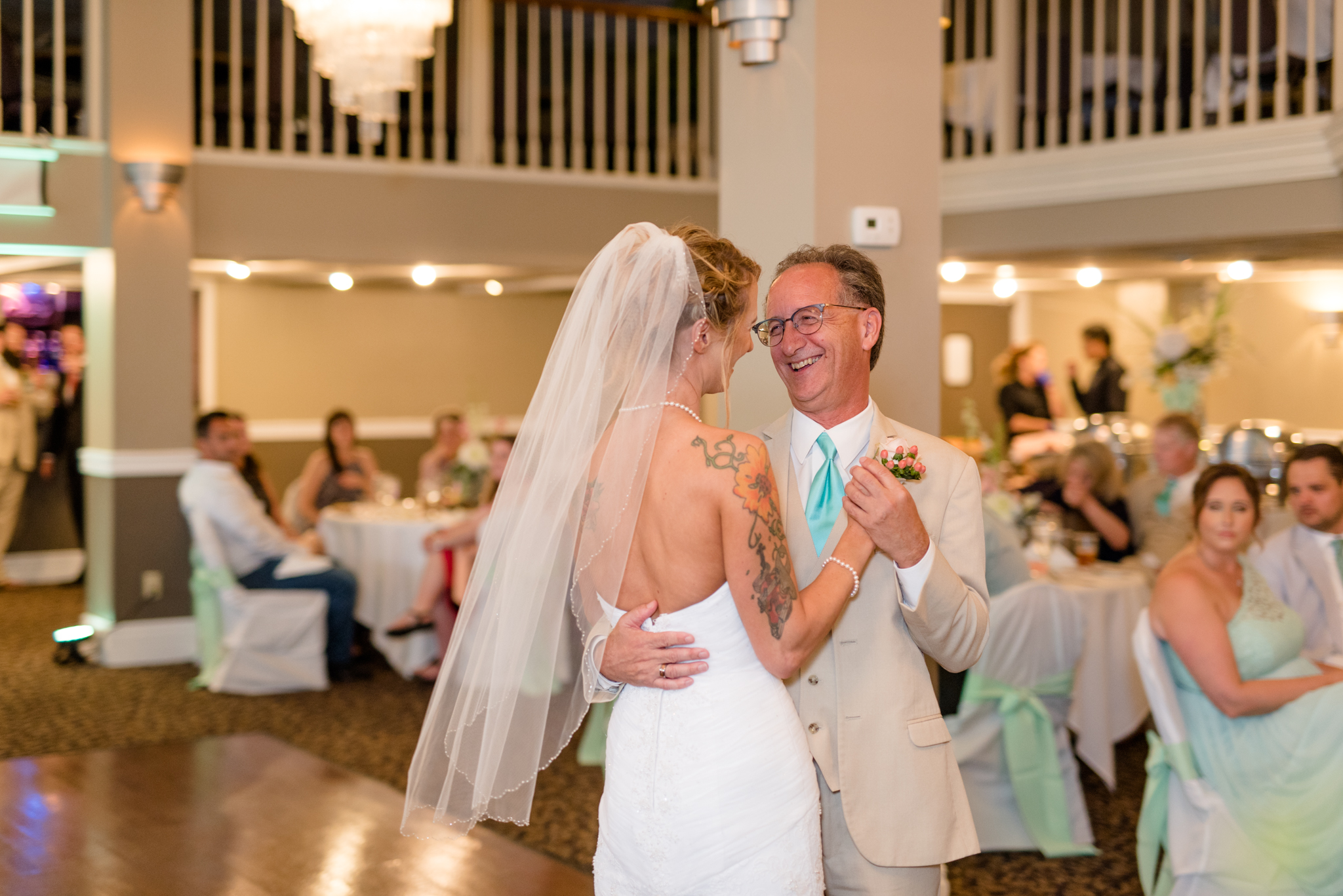 Bride dances with father at wedding reception.