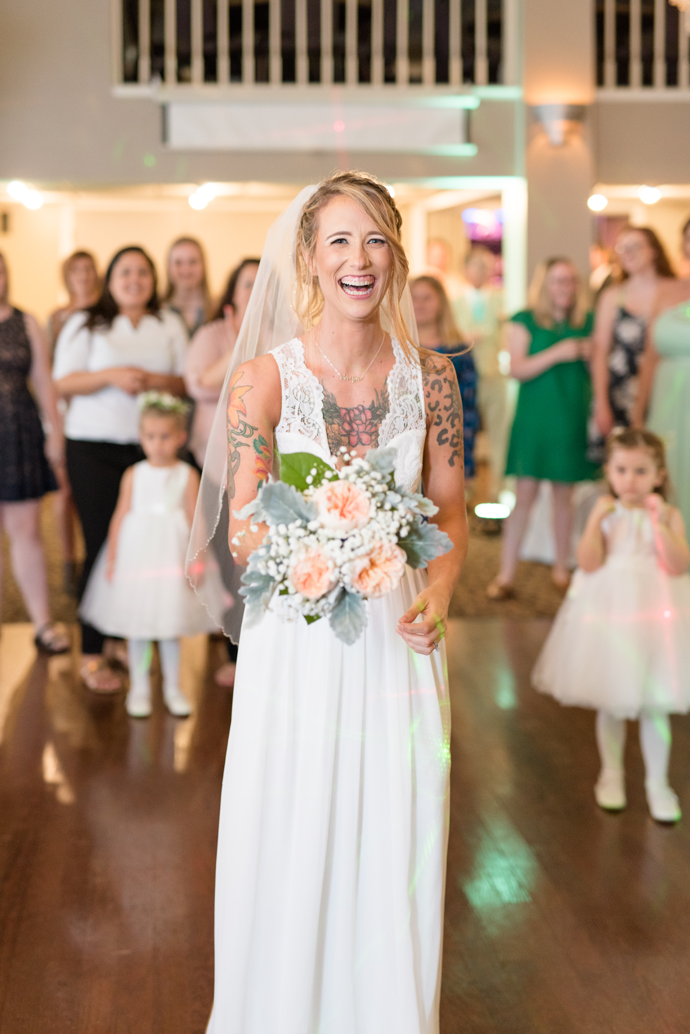 Bride smiles while tossing bouquet.