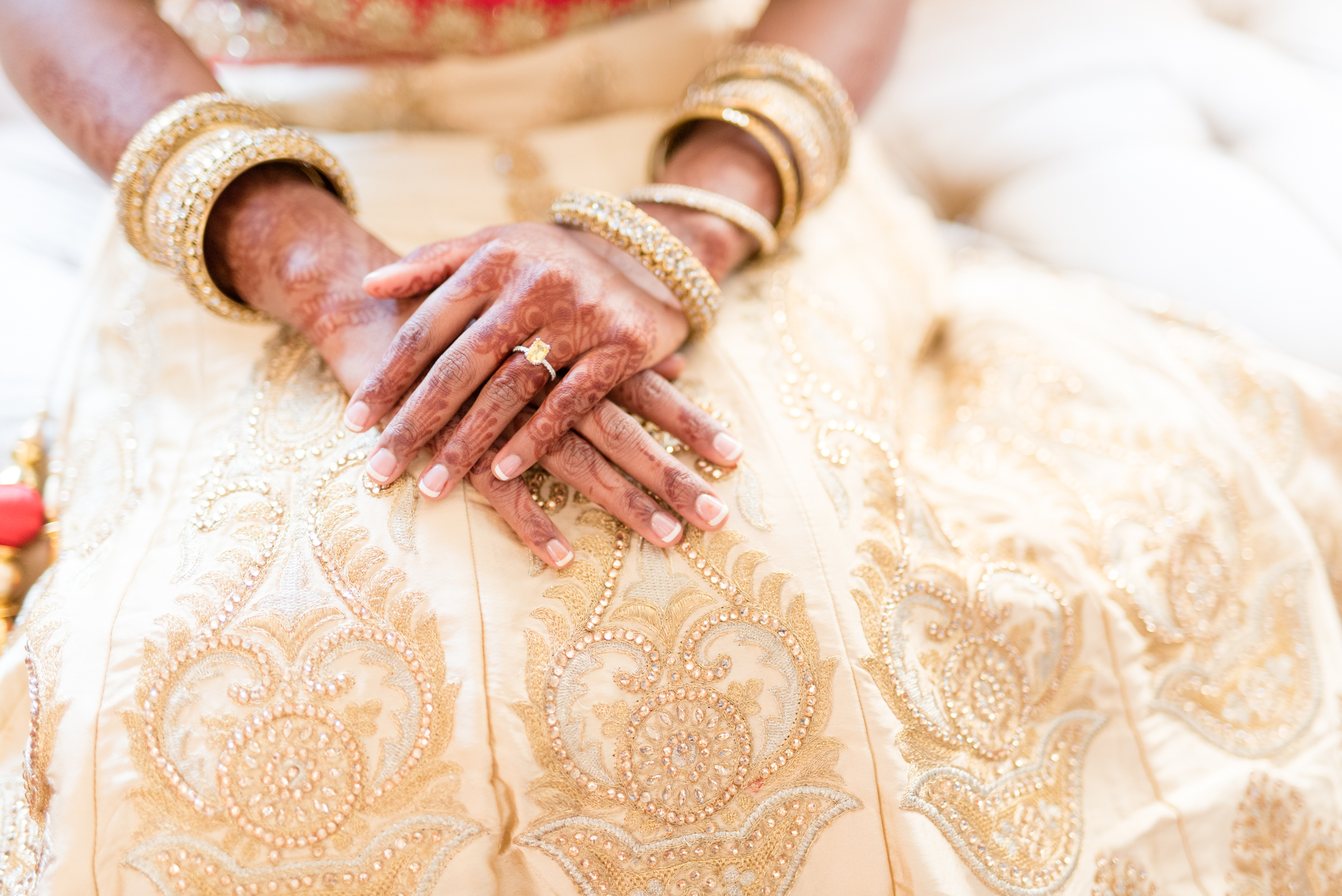 Bride rests hennaed hands on skirt.