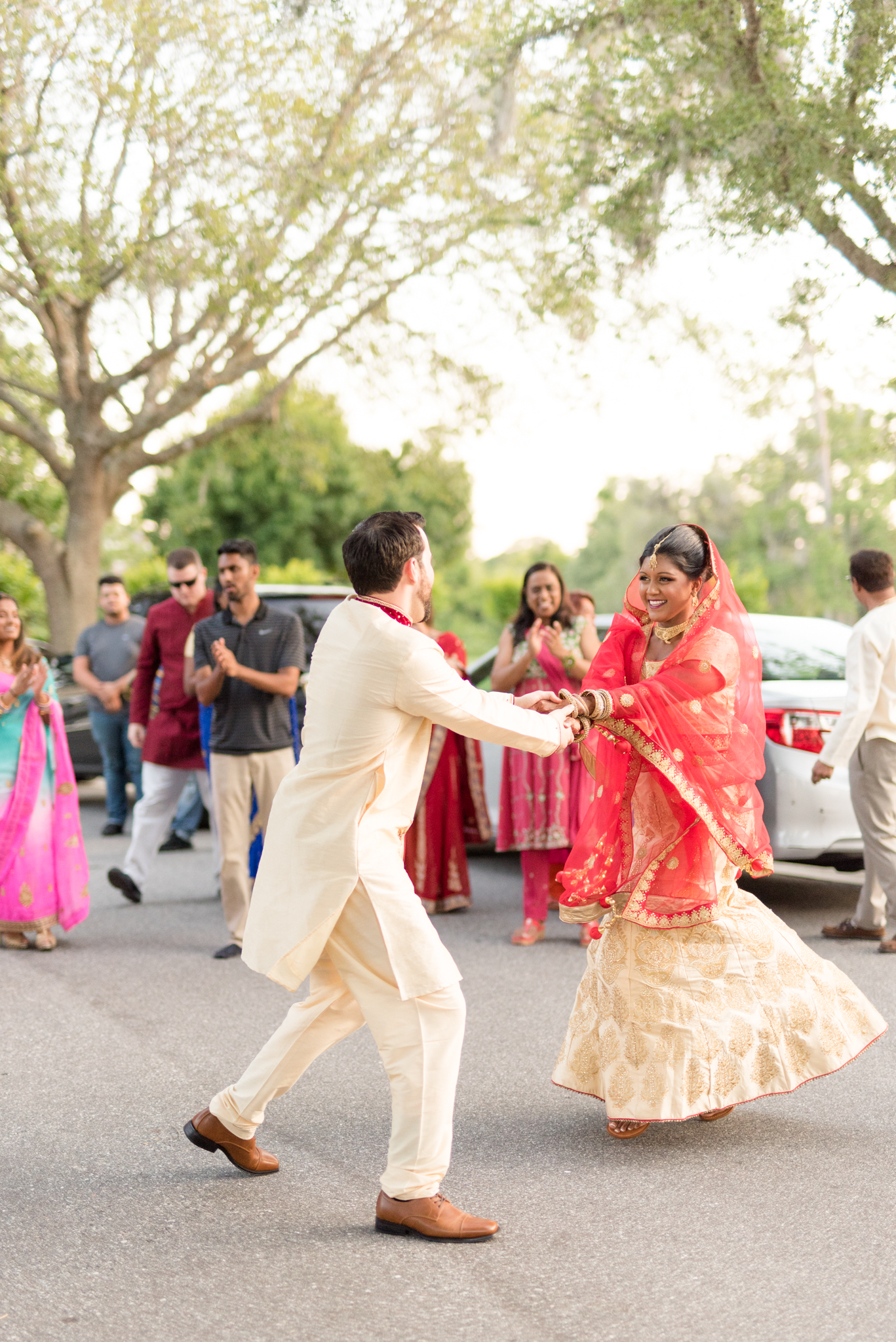 Indian bride and groom dance in street.