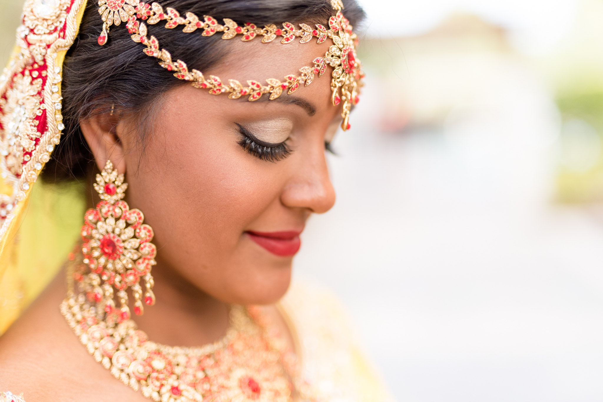 Bride looks down to show off makeup.