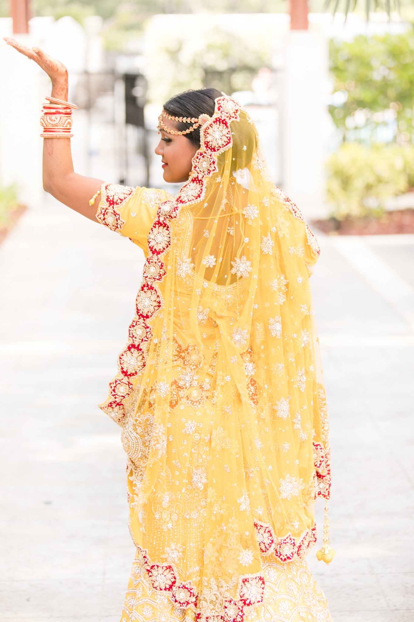 Bride looks over shoulder in Indian pose.