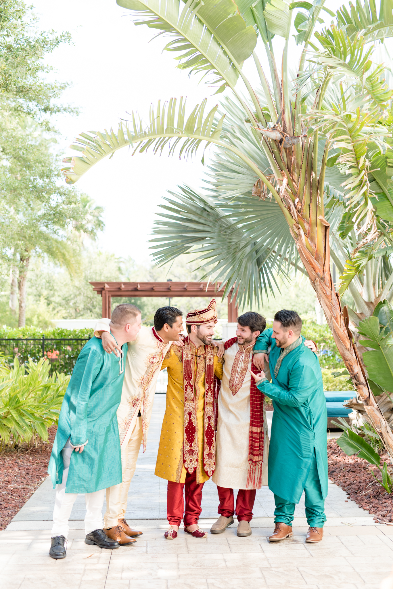 Groom and groomsmen laugh together.