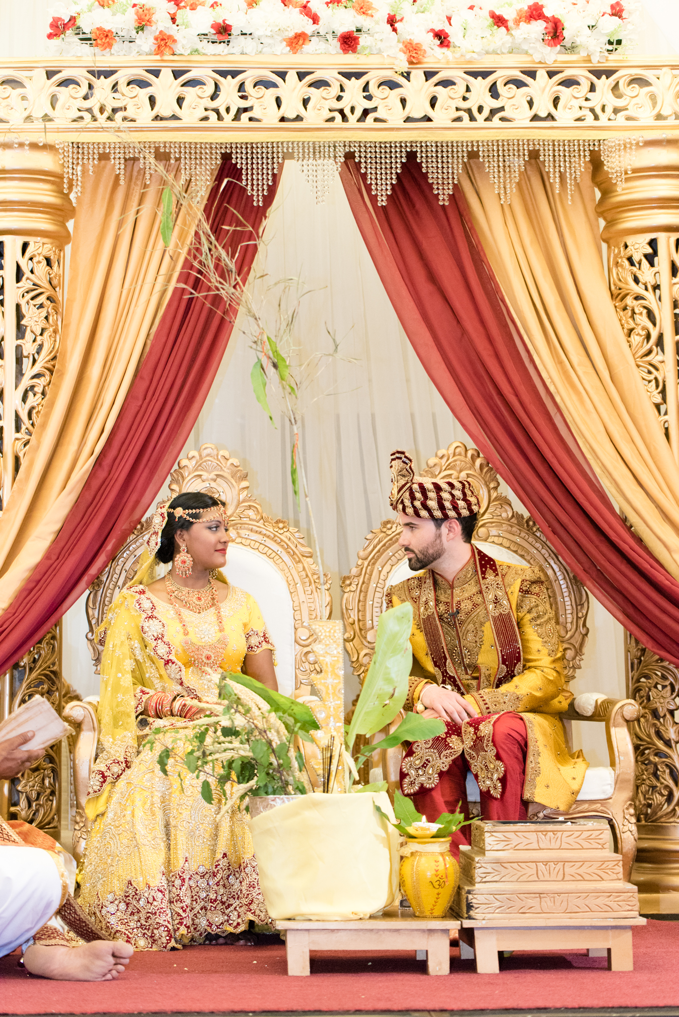 Bride and groom sit during their Indian wedding ceremony.