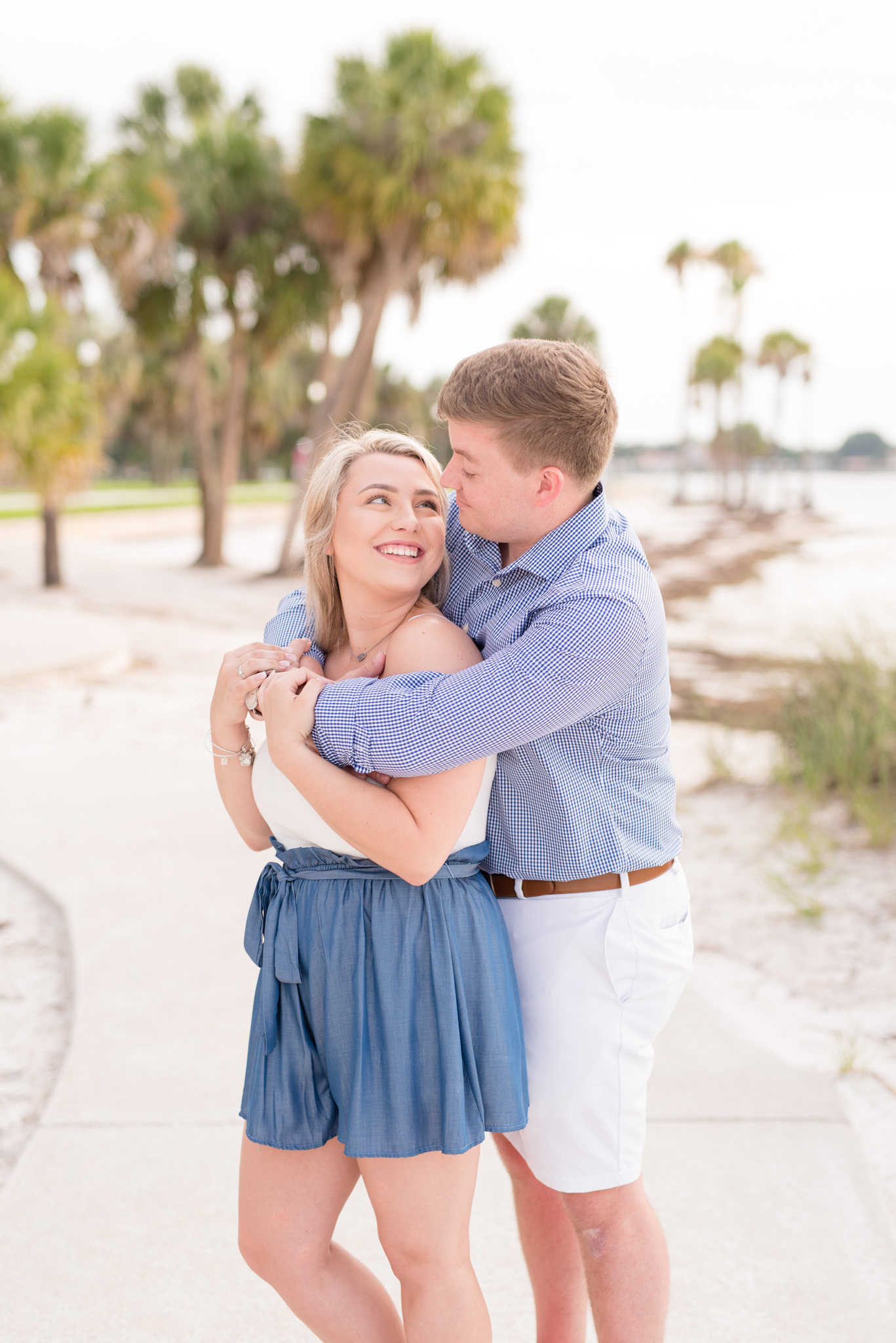 Couple snuggles on St. Petersburg beach walk.