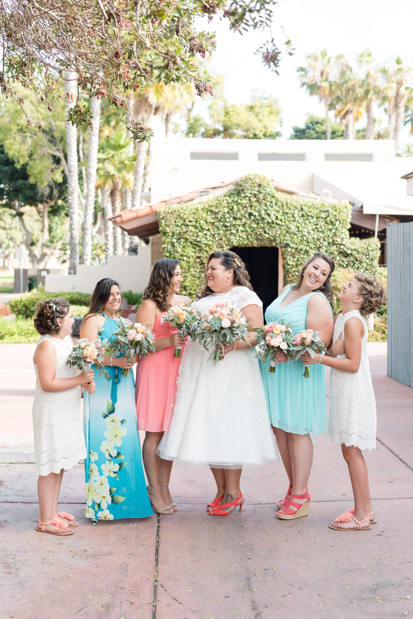 Bride and bridesmaids laugh together.