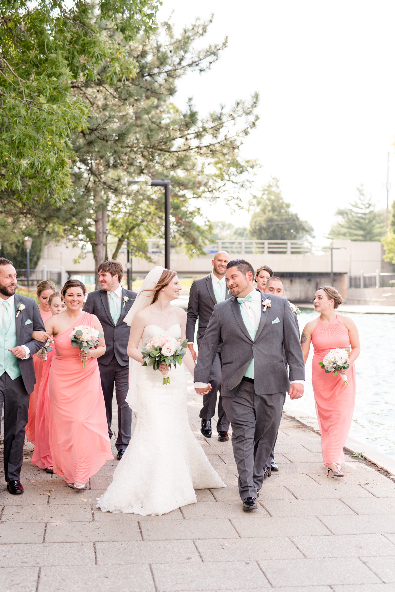 Bride and groom walk the Indianapolis canal with wedding party.