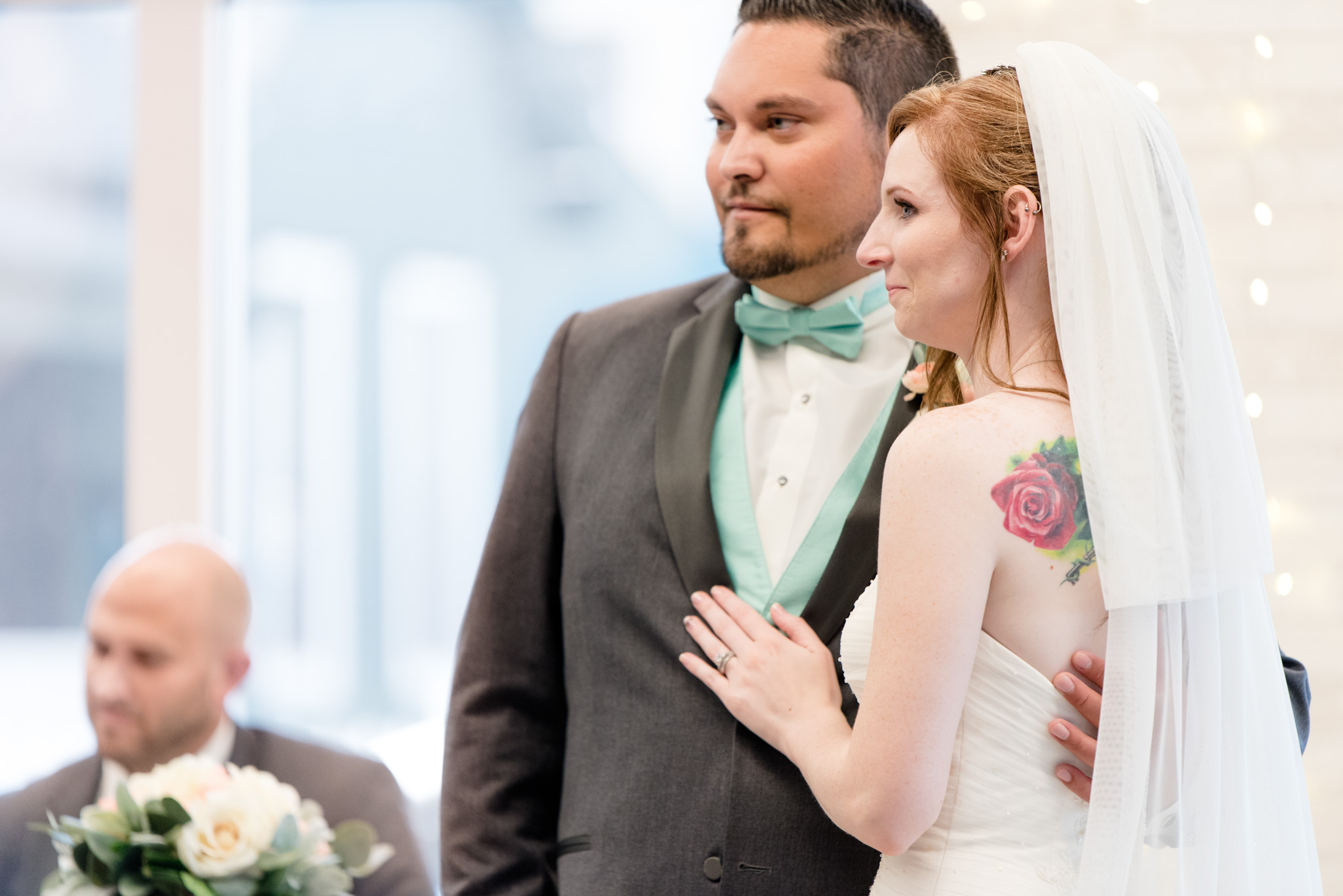 Bride and groom stand next to each other at reception.