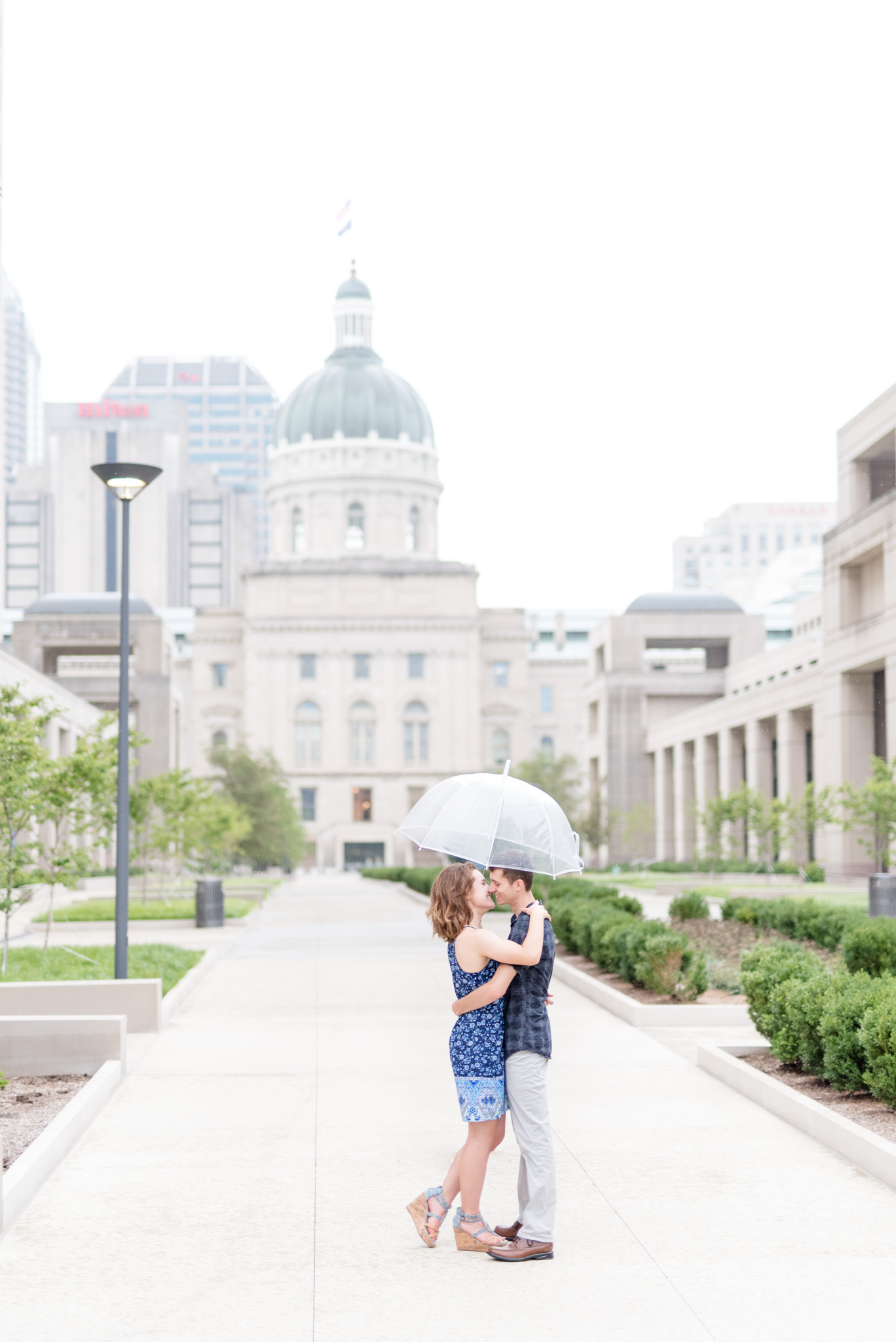 Couple kisses under umbrella.