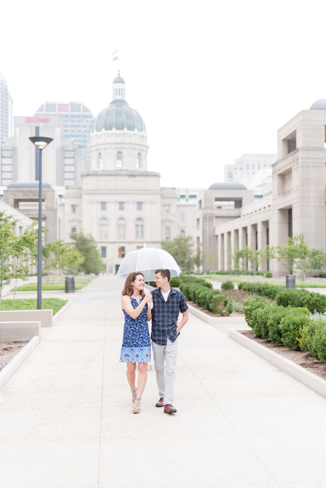 Couple walks under umbrella.