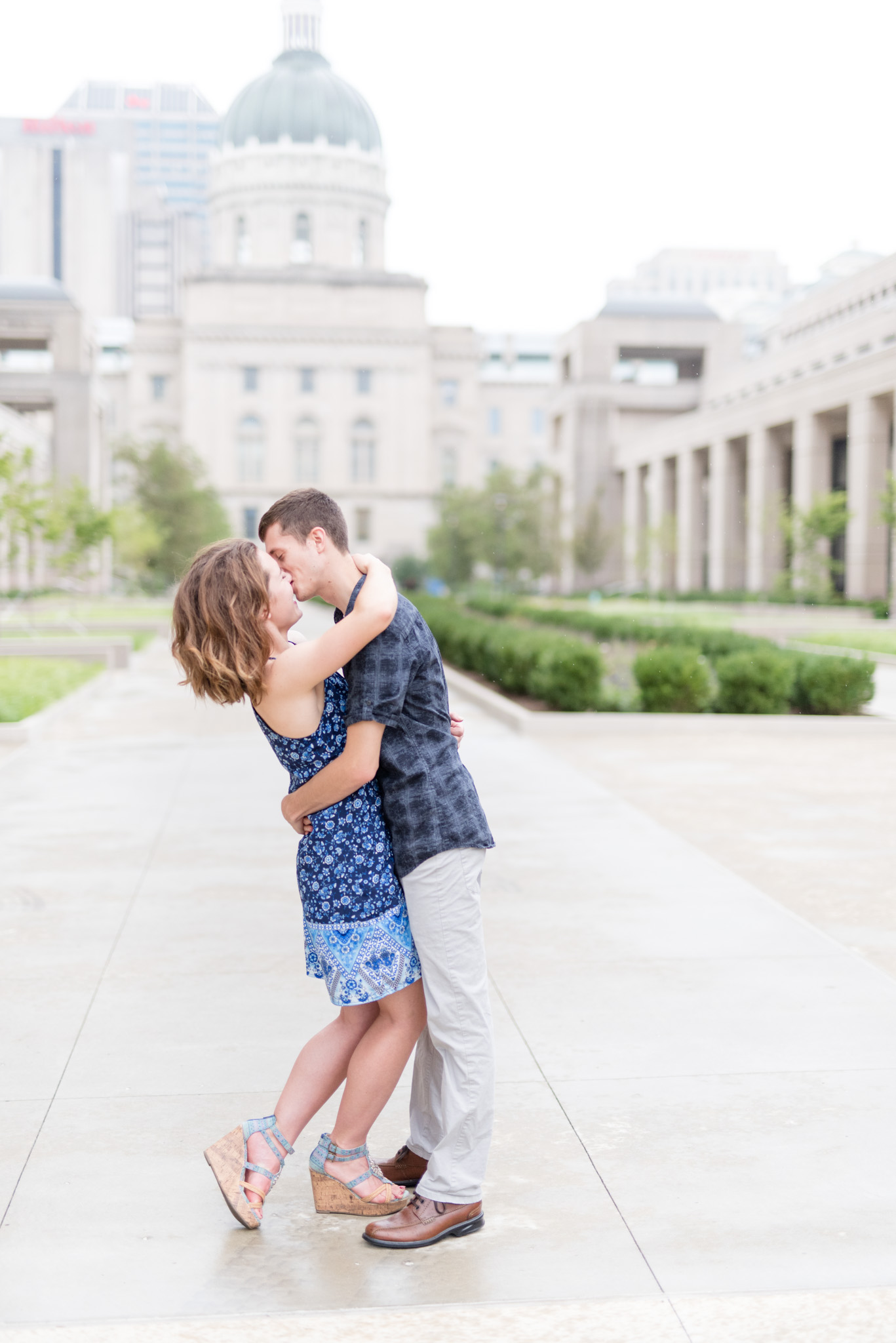 Couple kisses in front of Indiana State building.