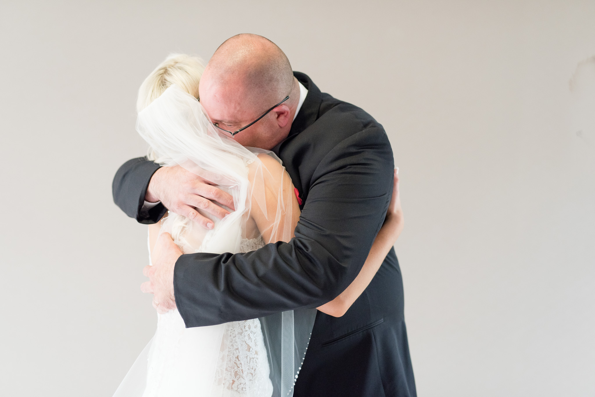 Father hugs bride.
