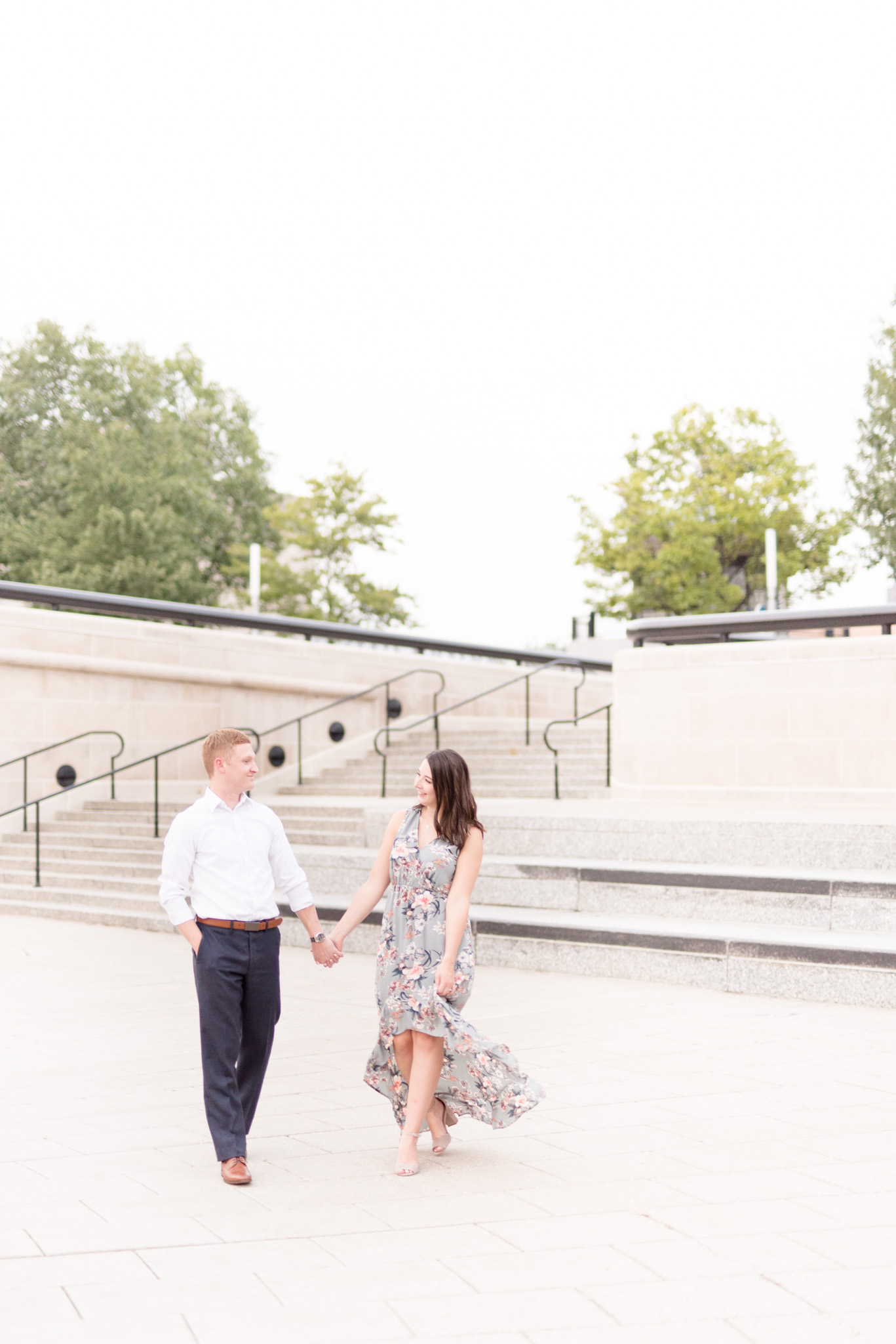 Couple walks across white stone path.