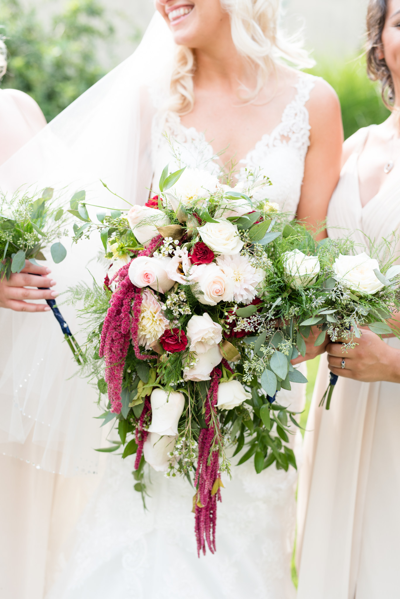 Bride laughs while holding flowers.